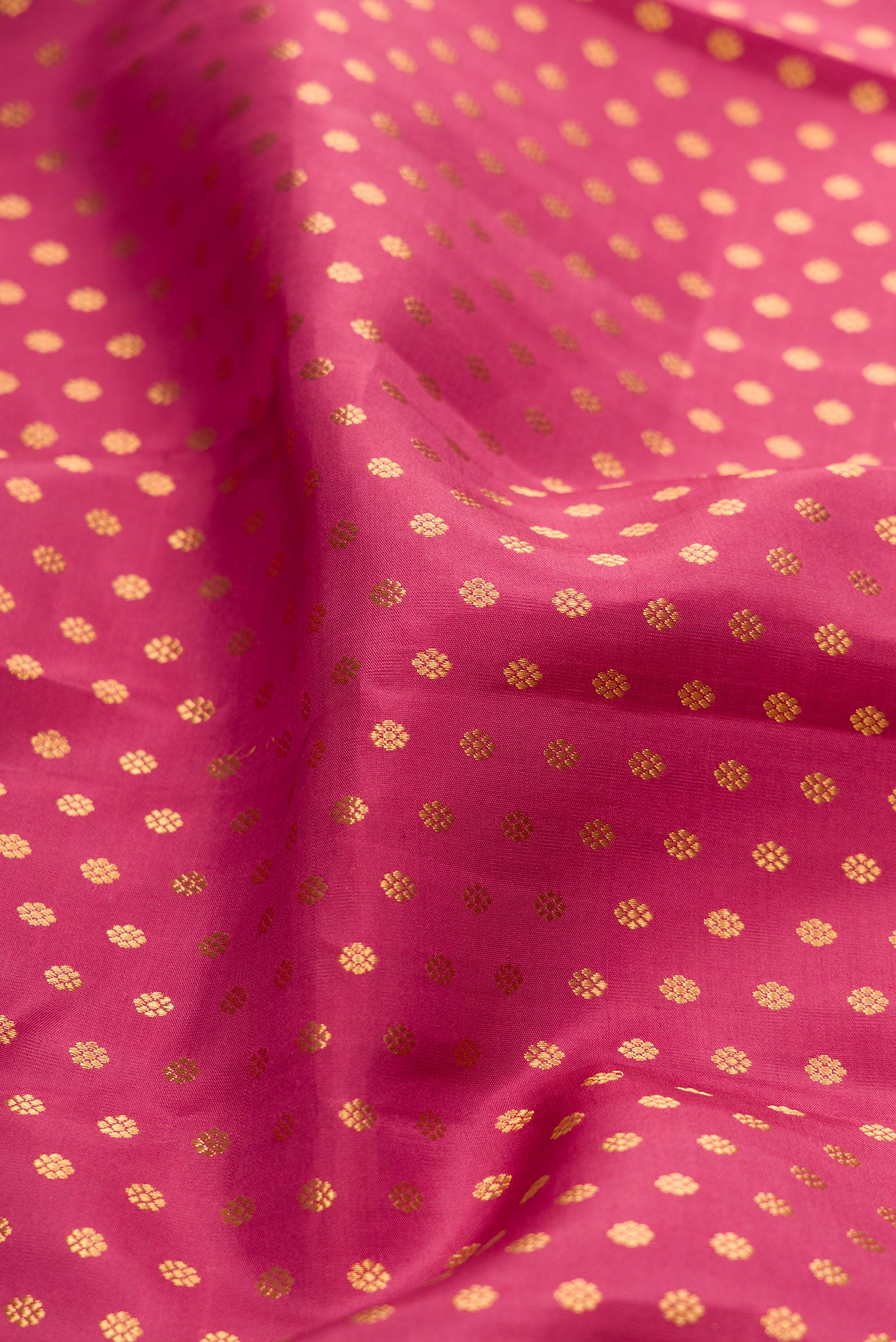Close up of Rose pink Kanchipuram Silk Saree with Zari Butta on the body and Zari Border.  displaying folds