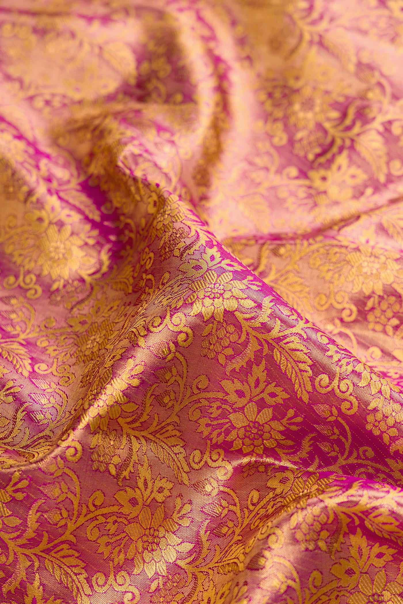 Close up of Rose Gold Dual Tone Kanchipuram Tissue Silk Saree with Zari Brocade on the body and Zari Border.  displaying folds