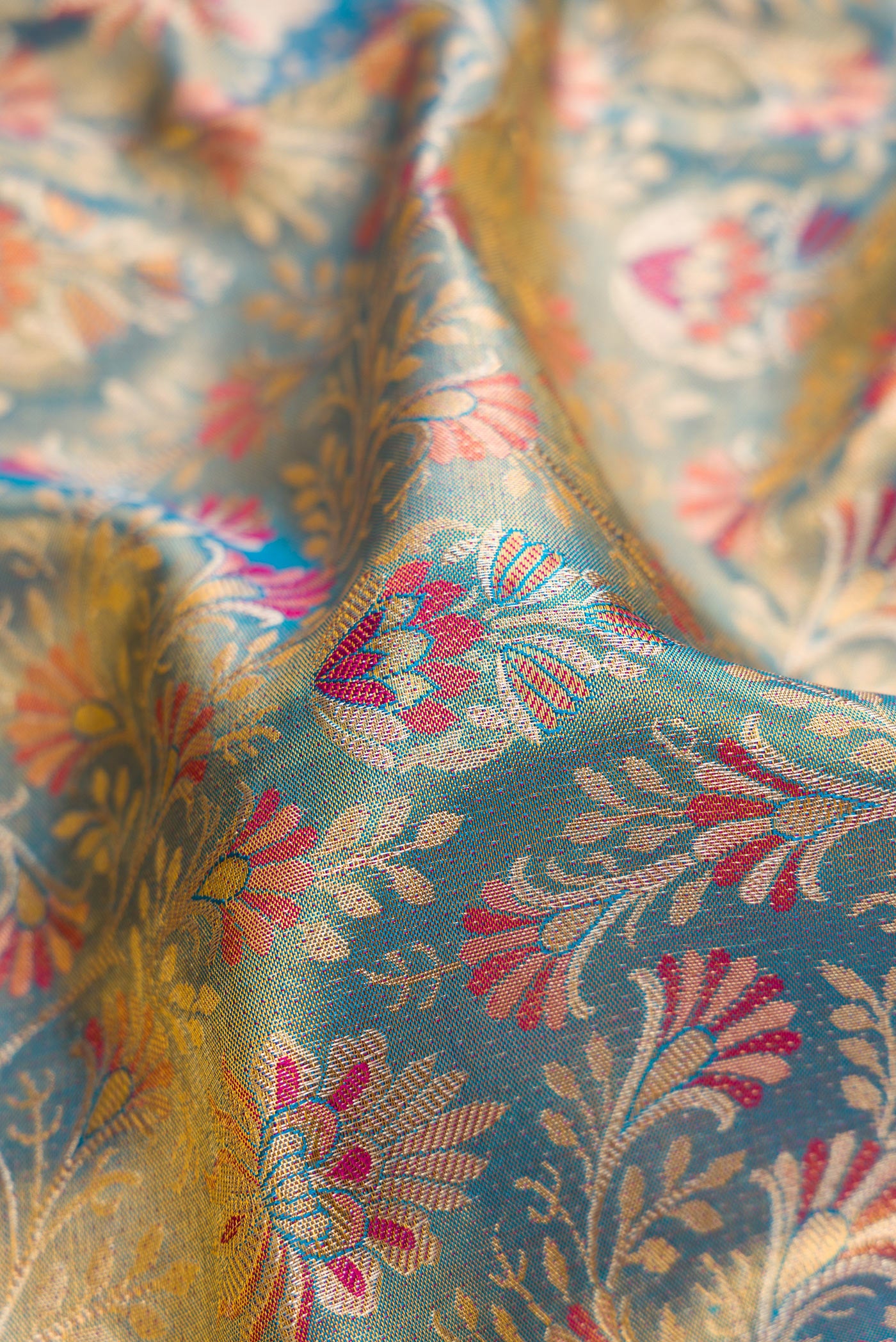 Close up of Blue Dual Tone Kanjivaram Tissue Silk Saree with Zari Brocade on the body and Fancy Border.  displaying folds