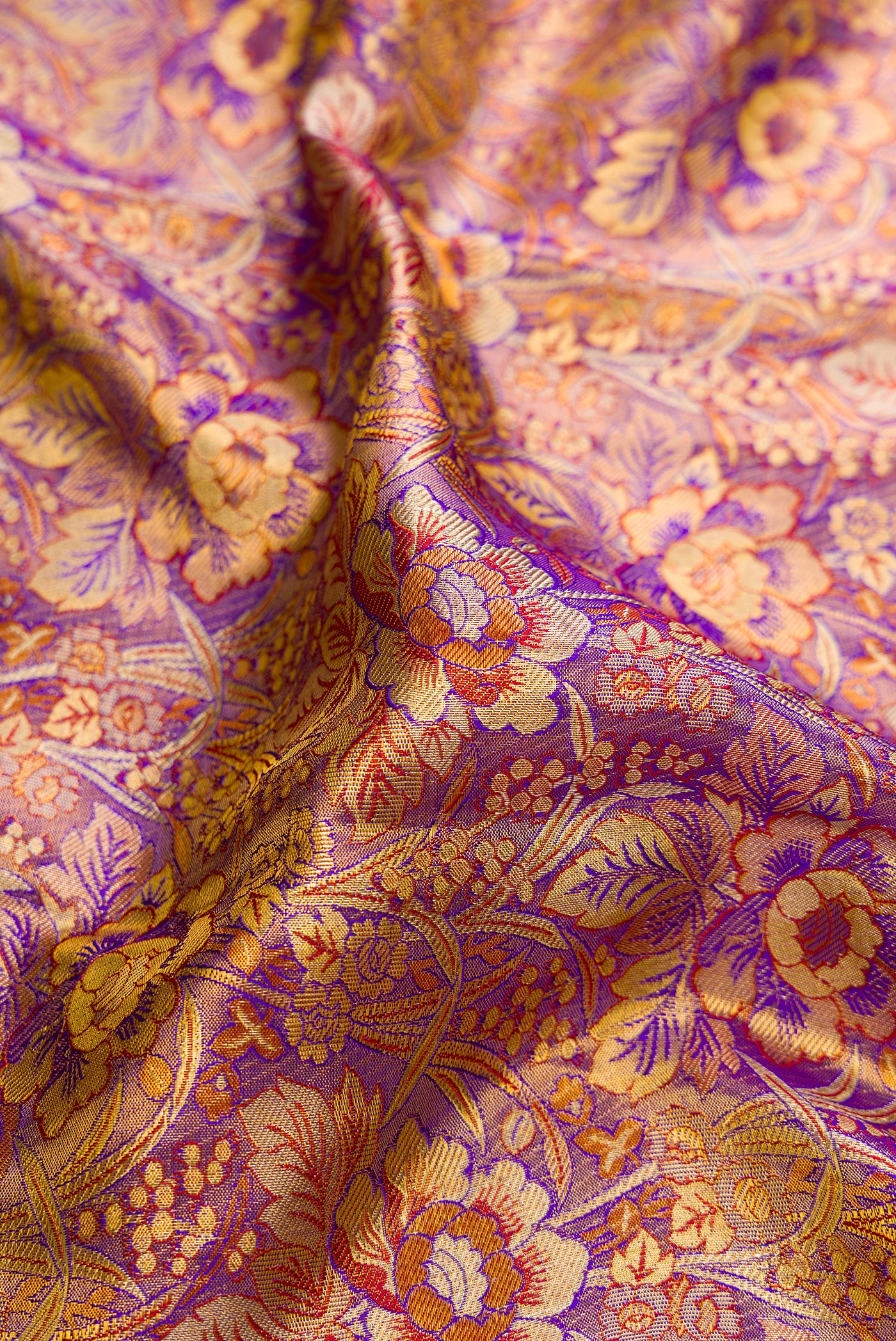 Close up of Purple Dual Tone Kanjivaram Tissue Silk Saree with Zari Brocade on the body and Zari Border.  displaying folds