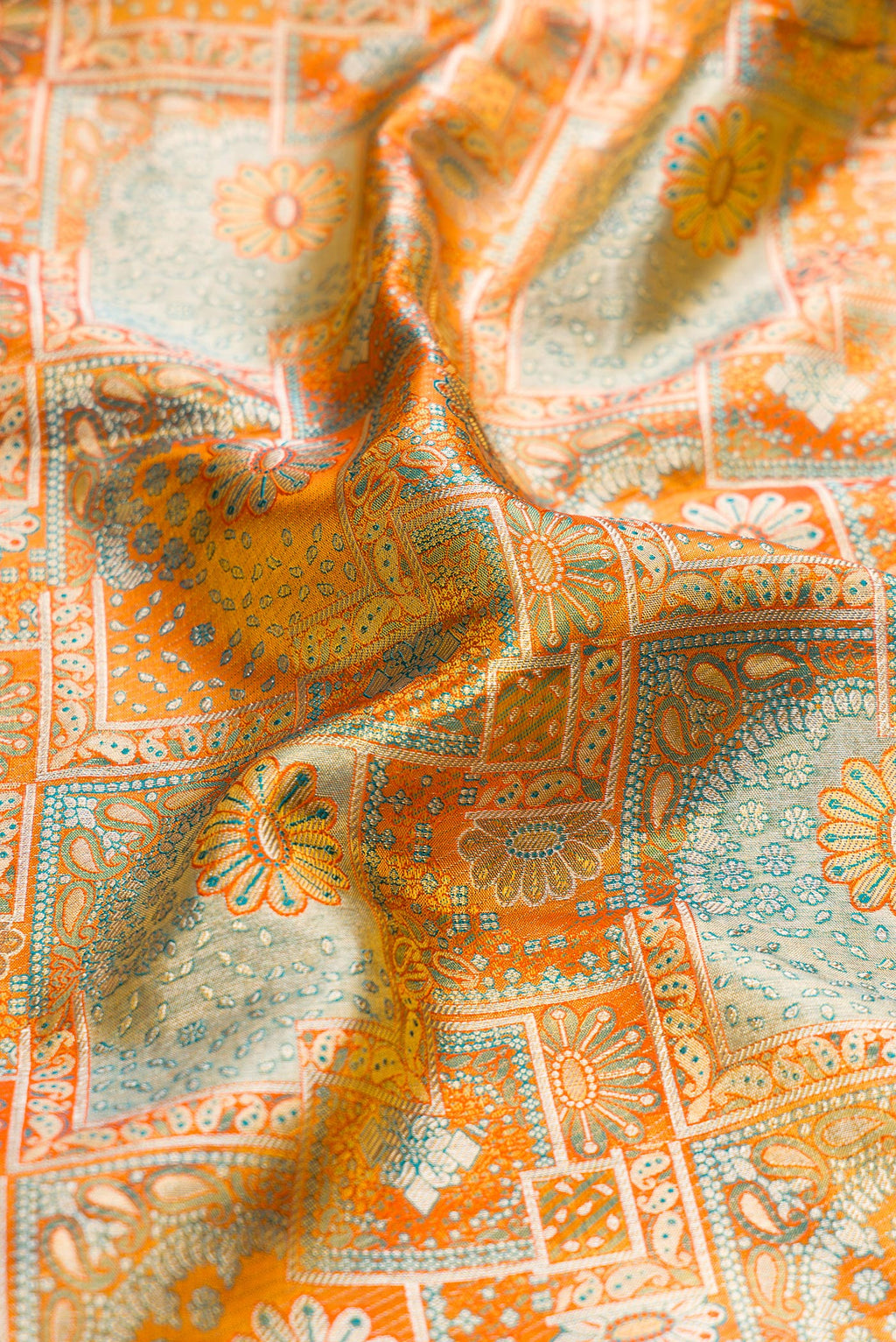 Close up of Orange Dual Tone Kanjivaram Tissue Silk Saree with Zari Brocade on the body and Zari Border.  displaying folds