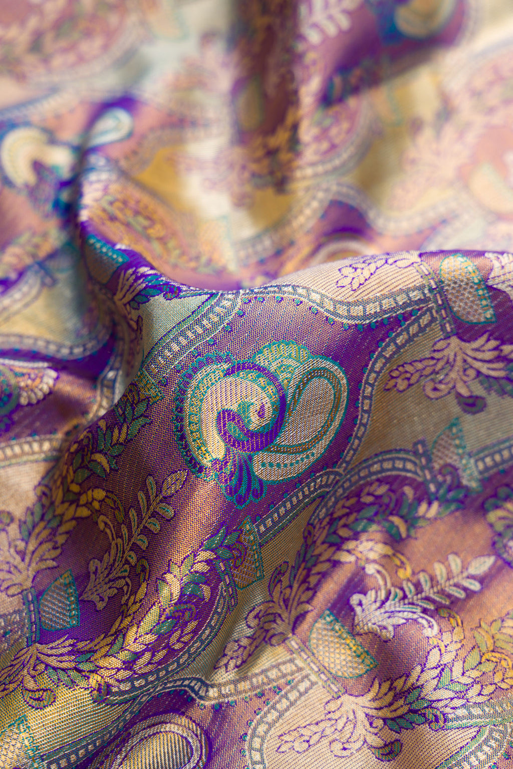 Close up of Purple Dual Tone Kanjivaram Tissue Silk Saree with Zari Brocade on the body and Zari Border.  displaying folds