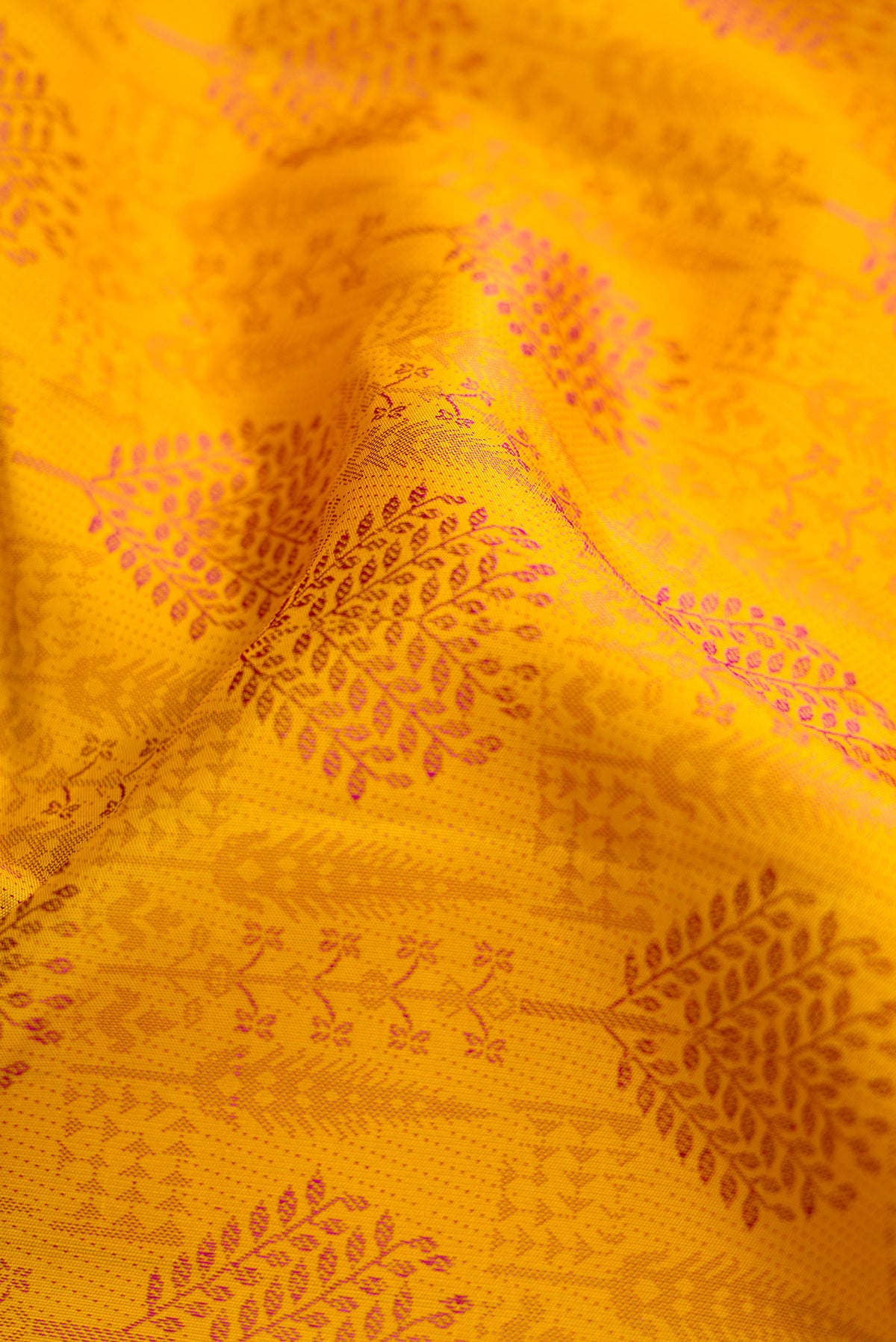 Close up of Yellow Dual Tone Kanjivaram Silk Saree with Jacquard design on the body and Fancy Border.  displaying folds