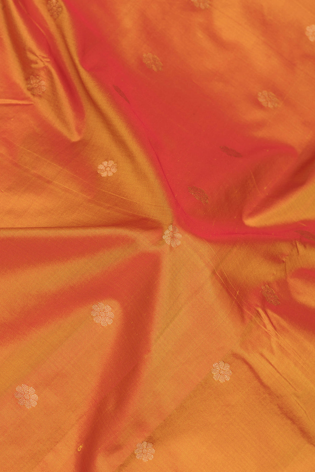 Close up of Orange Paithani Silk Saree with Zari Butta on the body and Zari Border.  displaying folds
