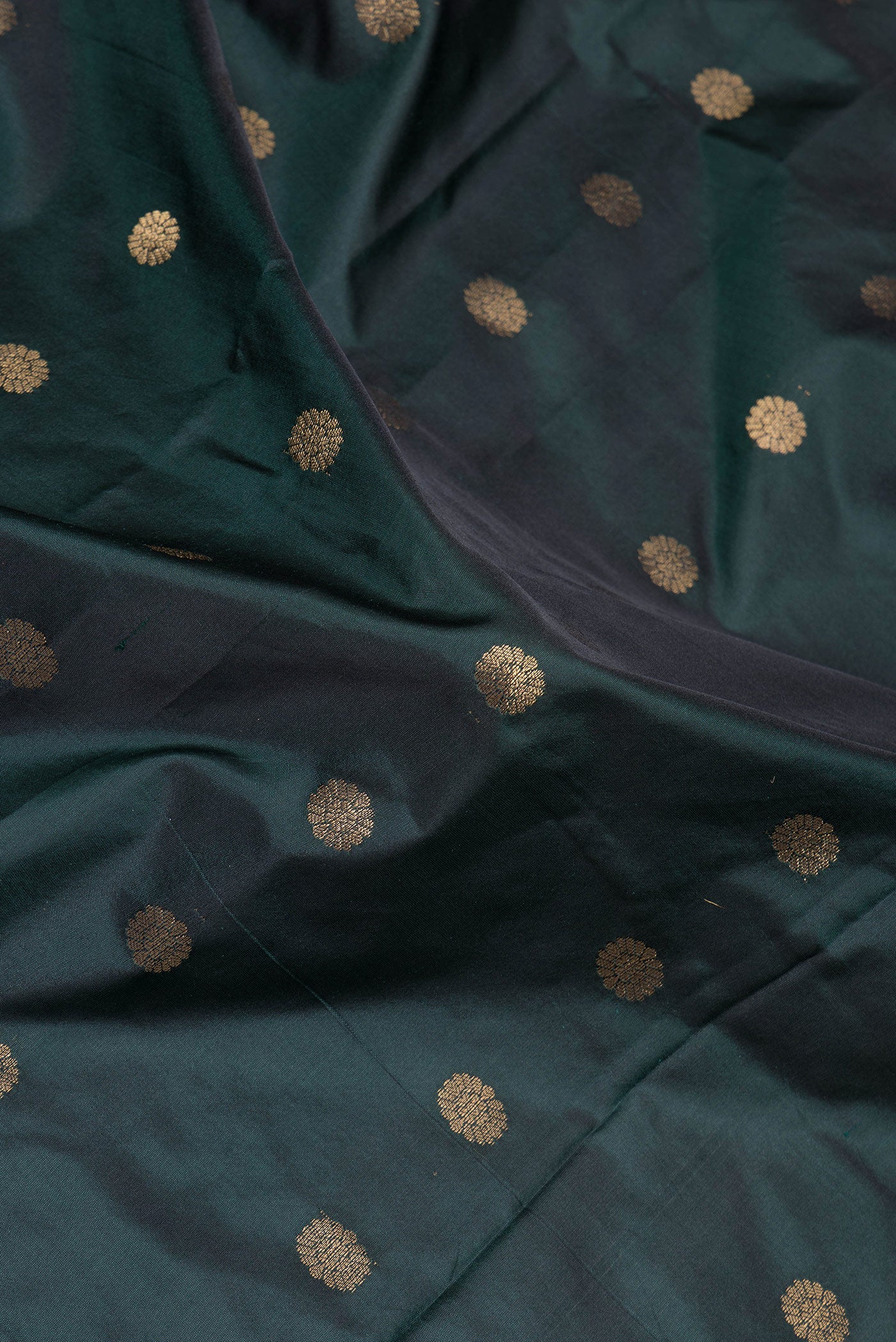 Close up of Bottle Green Paithani Silk Saree with Zari Butta on the body and Zari Border.  displaying folds