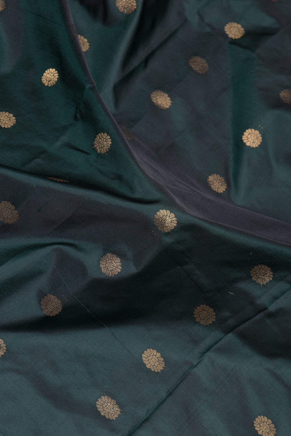 Close up of Bottle Green Paithani Silk Saree with Zari Butta on the body and Zari Border.  displaying folds