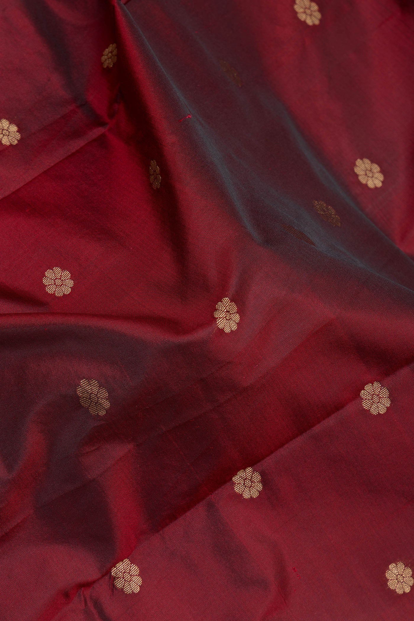 Close up of Maroon Blended Paithani Silk Saree with Zari Butta on the body and Zari Border.  displaying folds