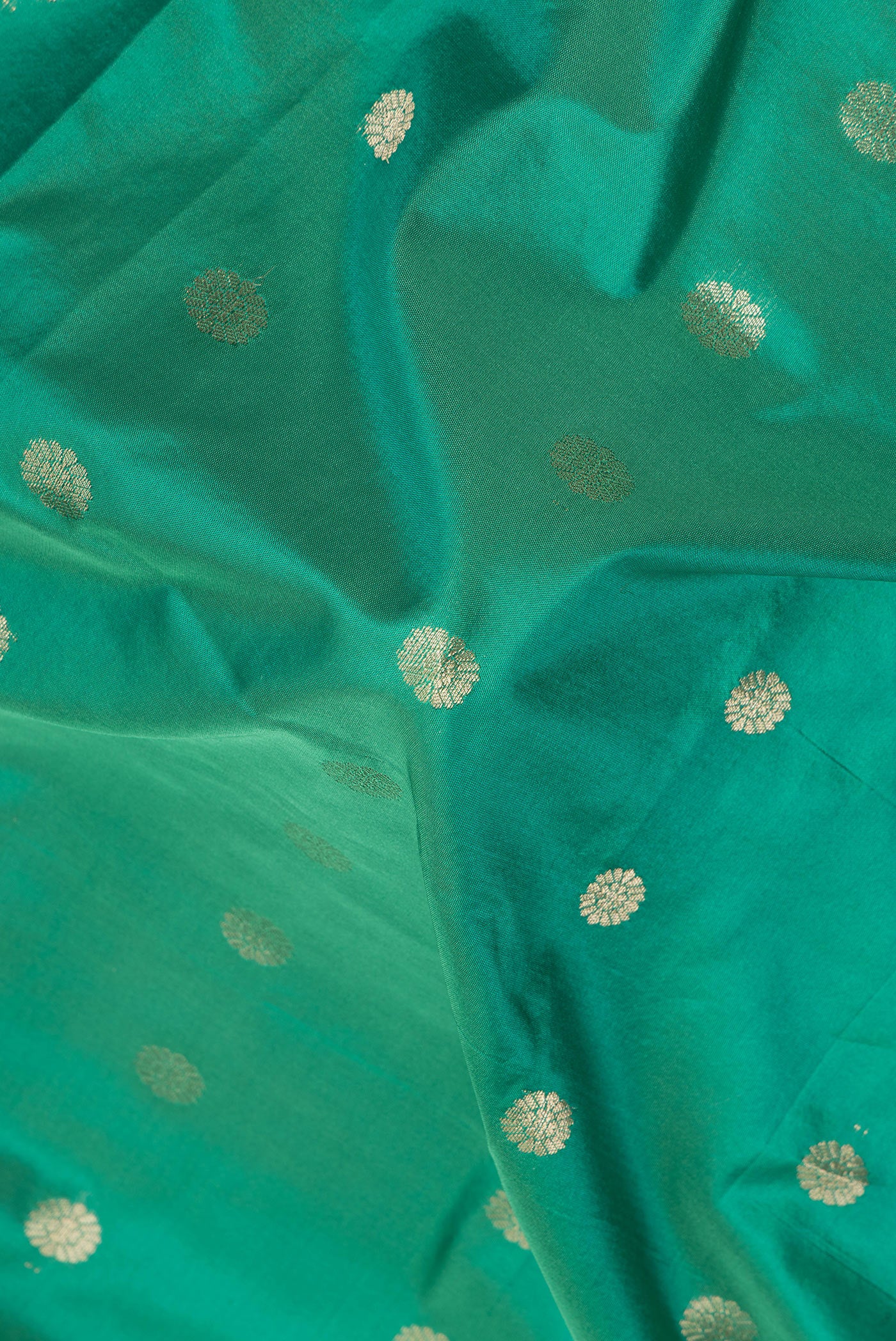 Close up of Green Blended Paithani Silk Saree with Zari Butta on the body and Zari Border.  displaying folds