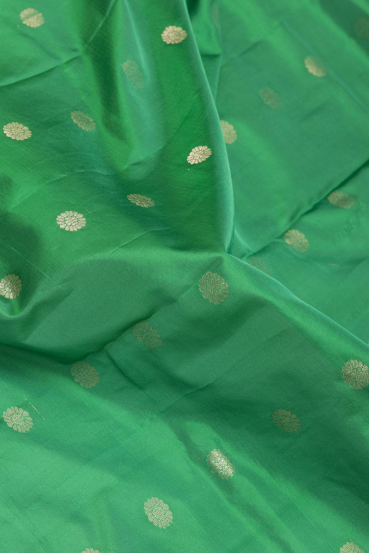 Close up of Green Paithani Silk Saree with Zari Butta on the body and Zari Border.  displaying folds