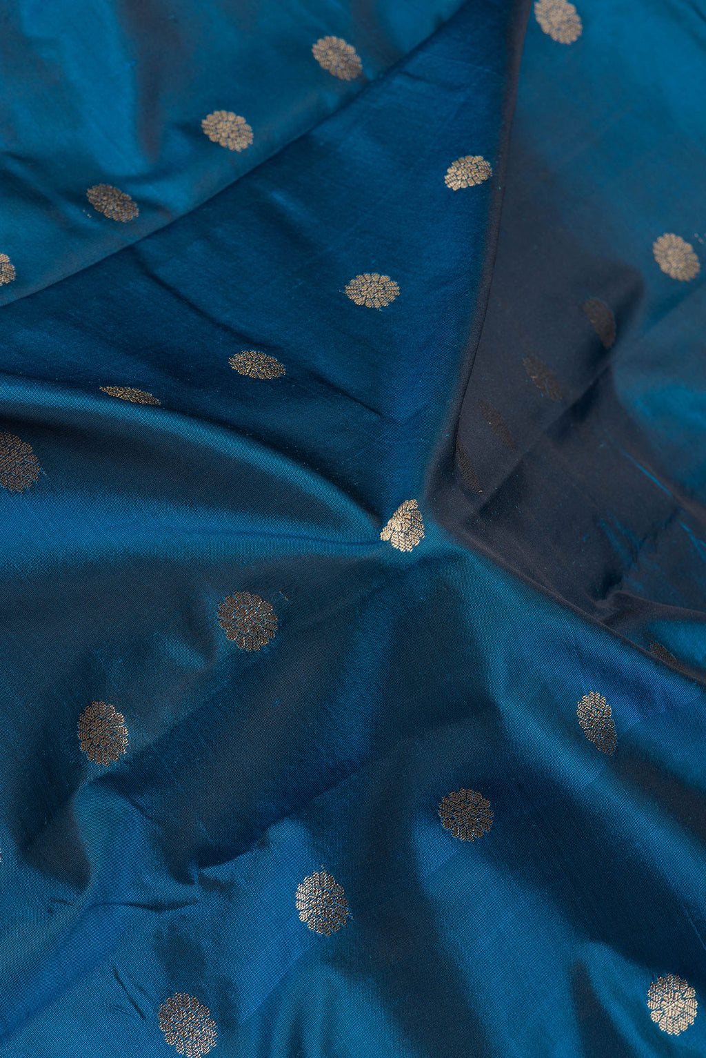 Close up of Peacock Blue Blended Paithani Silk Saree with Zari Butta on the body and Zari Border.  displaying folds