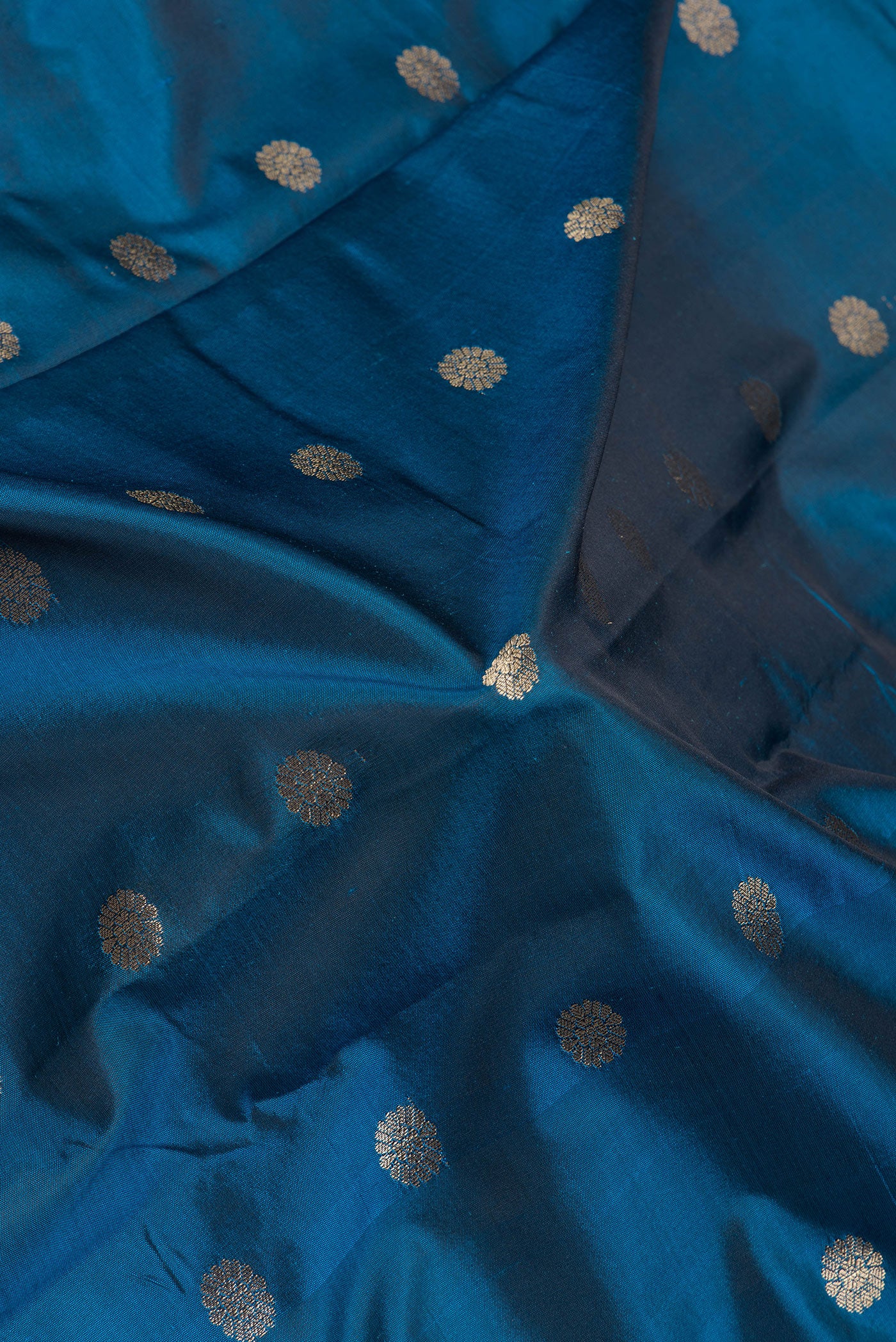 Close up of Peacock Blue Blended Paithani Silk Saree with Zari Butta on the body and Zari Border.  displaying folds