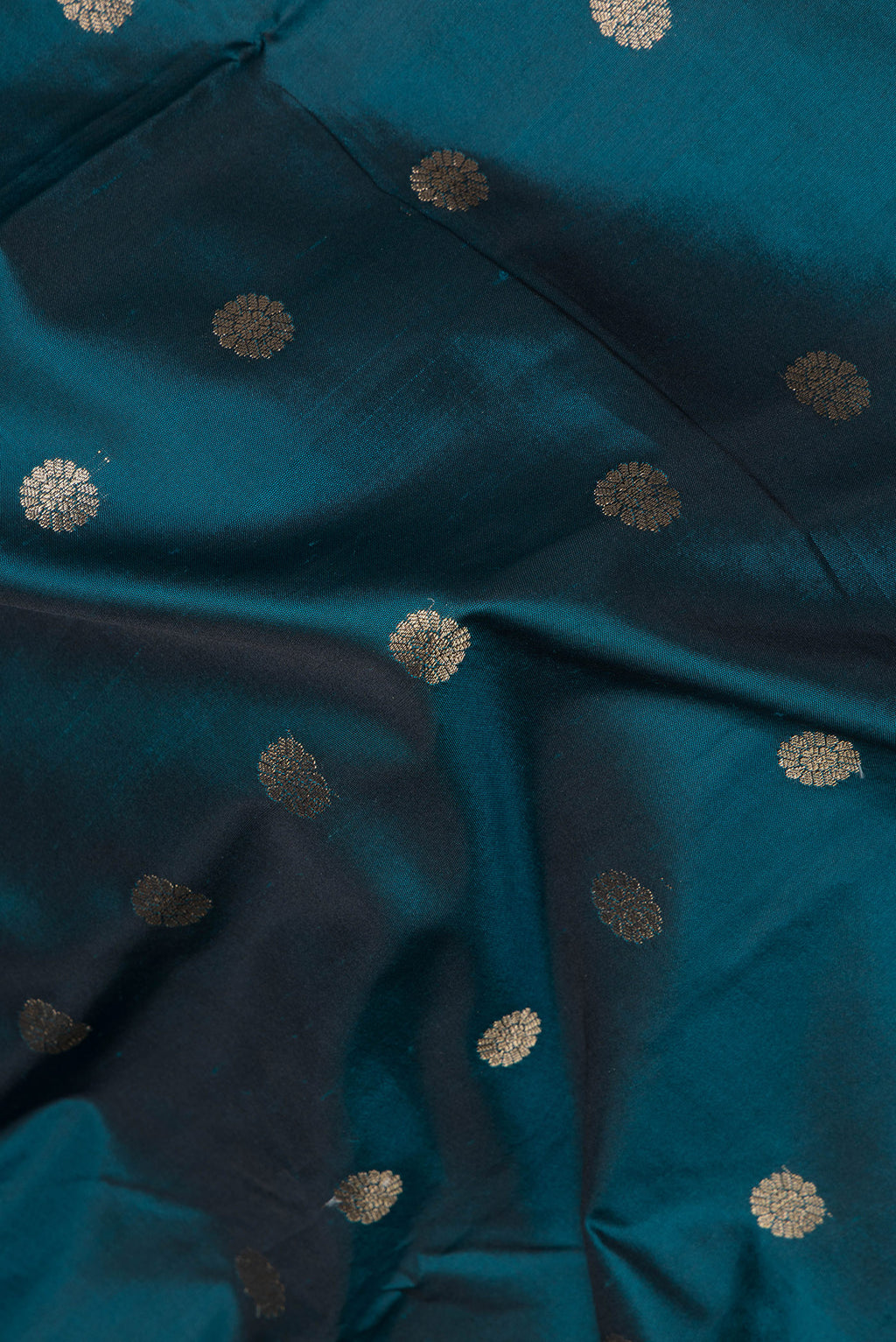 Close up of Peacock Blue Blended Paithani Silk Saree with Zari Butta on the body and Zari Border.  displaying folds