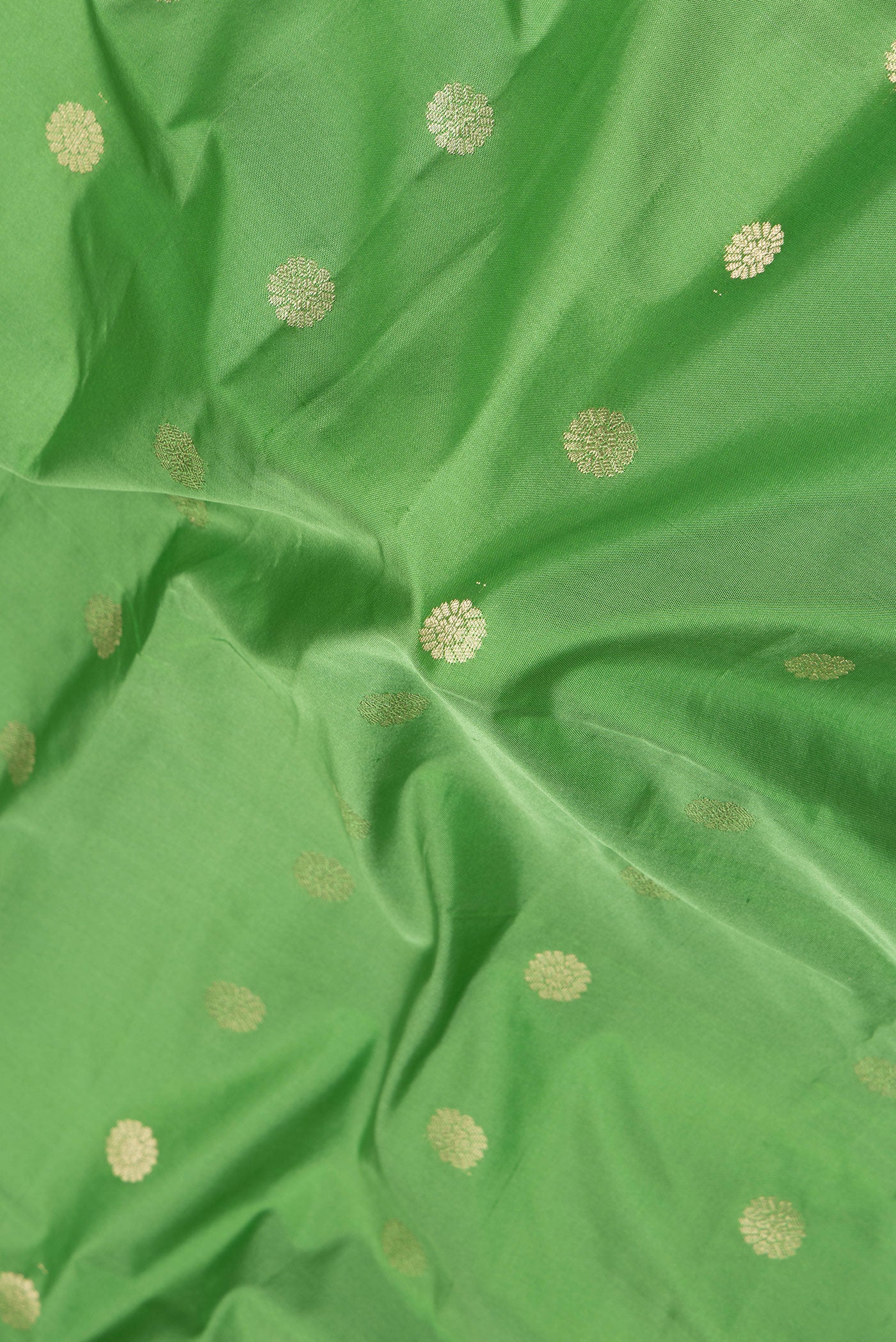 Close up of Green Paithani Silk Saree with Zari Butta on the body and Zari Border.  displaying folds