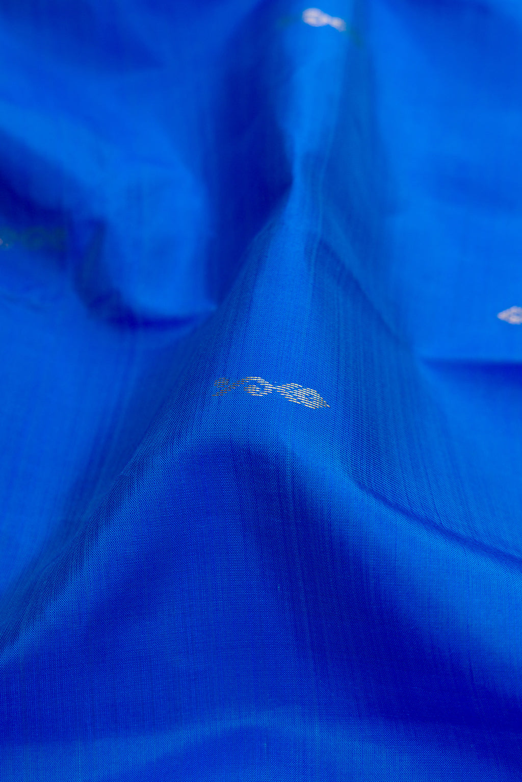 Close up of Blue Kanchipuram Silk Saree with Zari Butta on the body and Fancy Border.  displaying folds