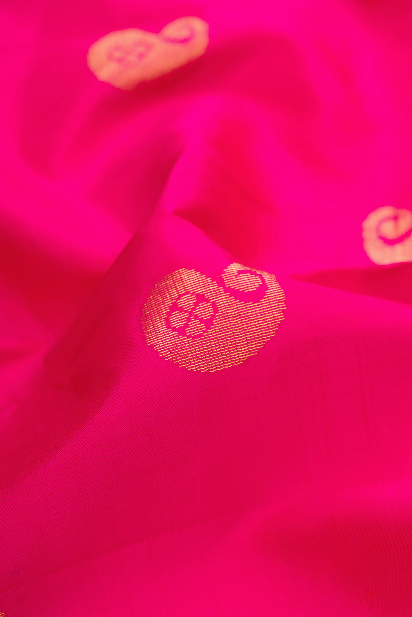 Close up of Dark Pink Kanchipuram Silk Saree with Zari Butta on the body and Fancy Border.  displaying folds