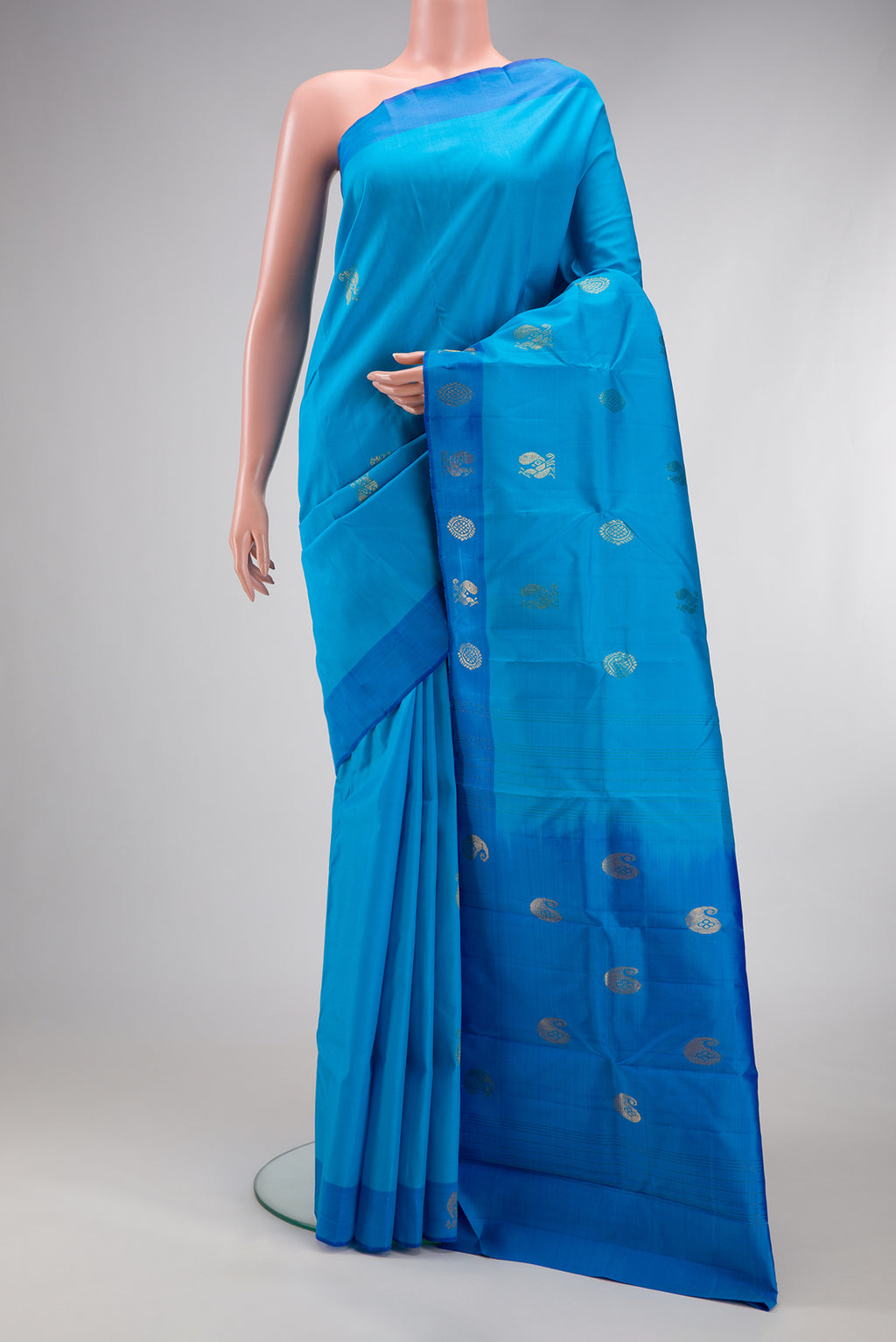 Sky Blue Kanchipuram Silk Saree with Zari Butta on the body and Fancy Border.  displayed on a mannequin