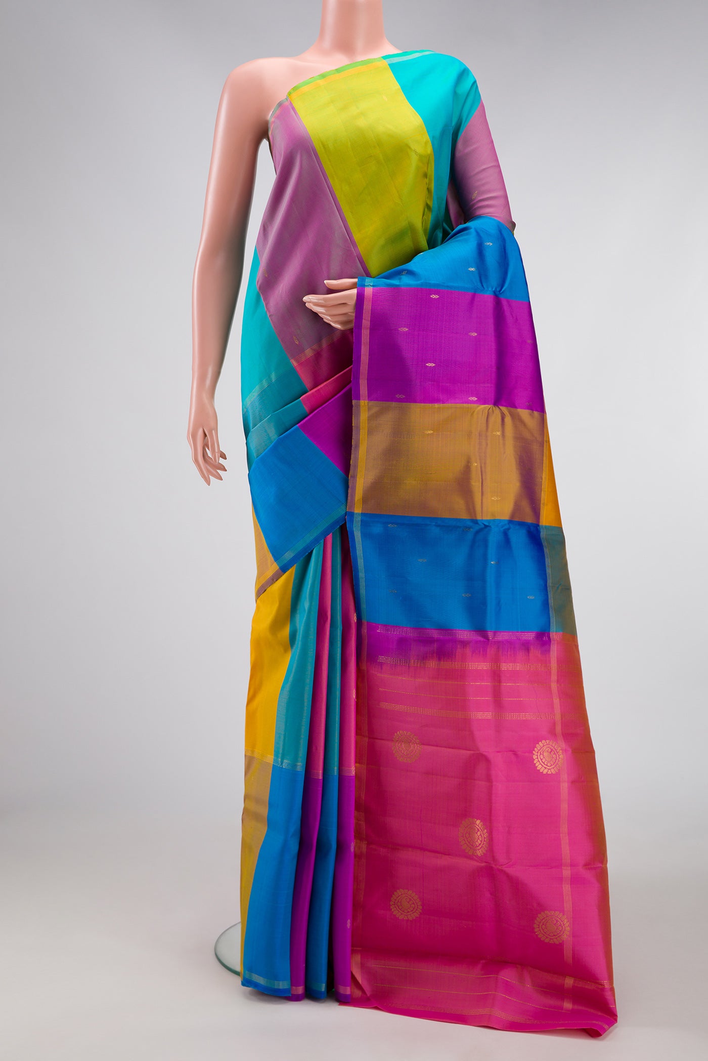 Multi Color Kanchipuram Silk Saree with Zari Butta on the body and Zari Border.  displayed on a mannequin