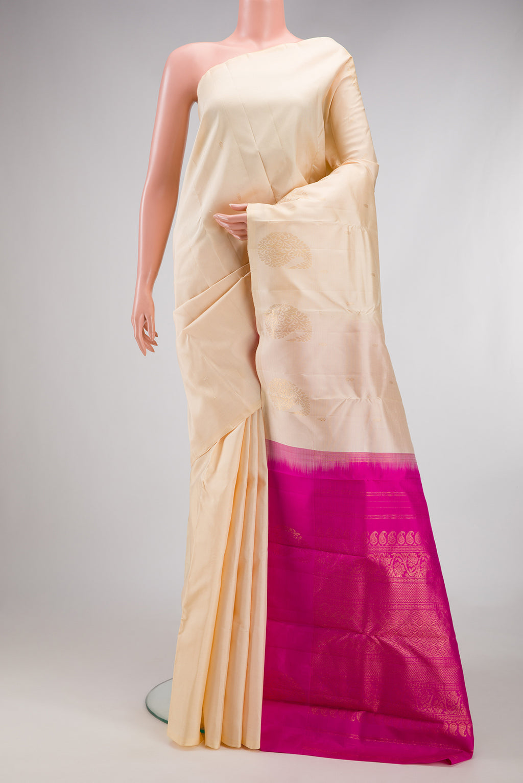 Cream Kanchipuram Silk Saree with Zari Butta on the body and Without Border.  displayed on a mannequin