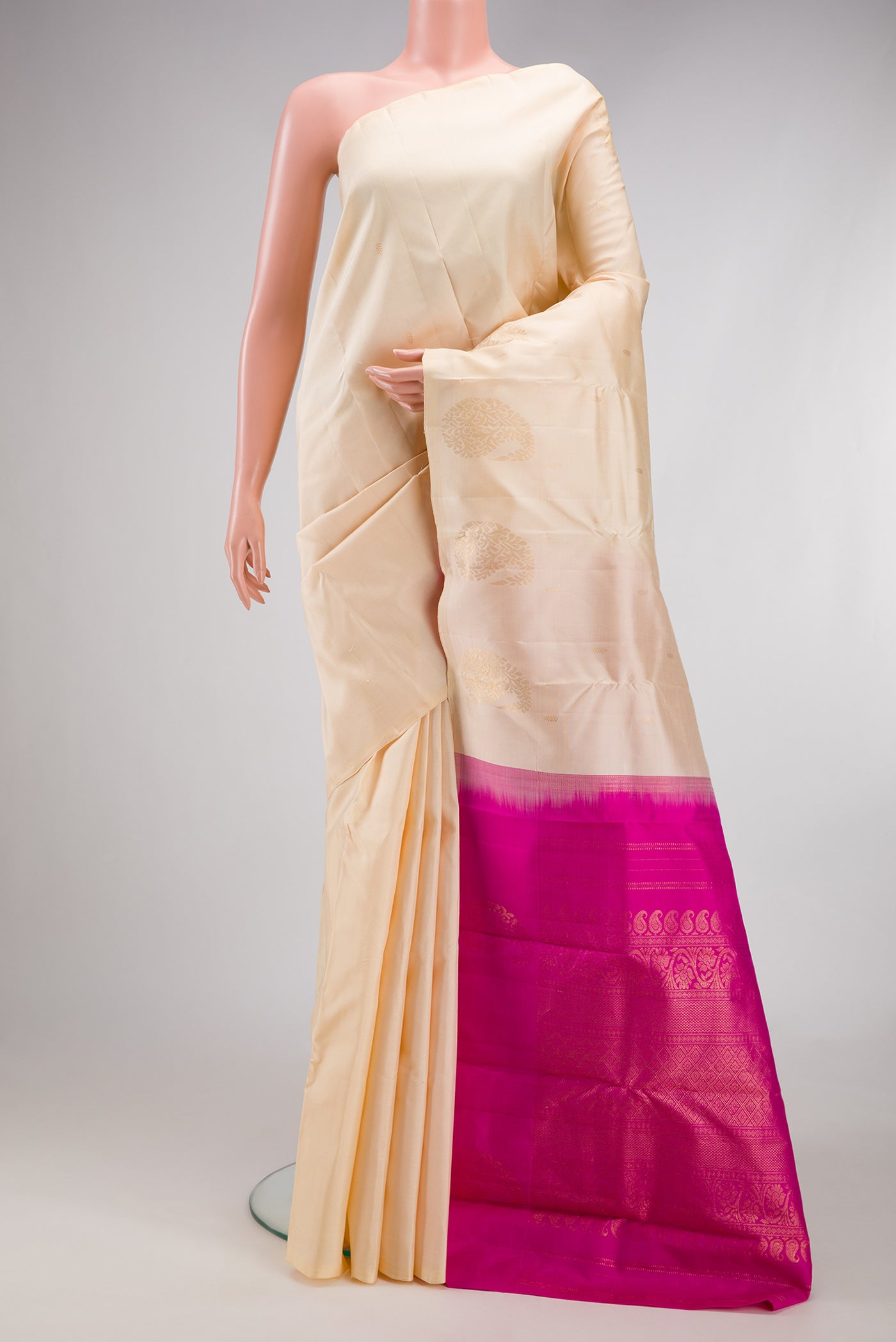 Cream Kanchipuram Silk Saree with Zari Butta on the body and Without Border.  displayed on a mannequin