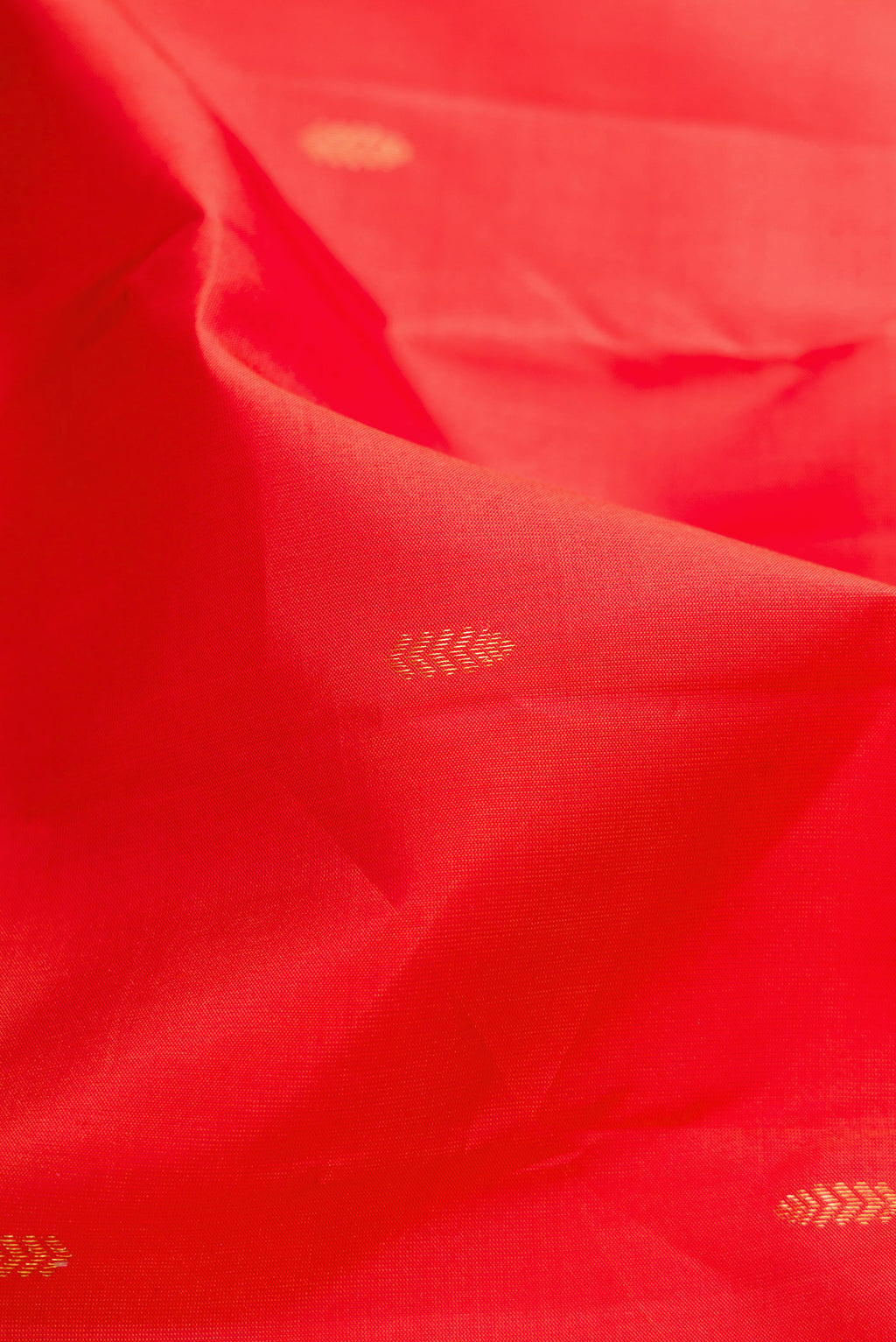 Close up of Red Kanchipuram Silk Saree with Zari Butta on the body and Without Border.  displaying folds