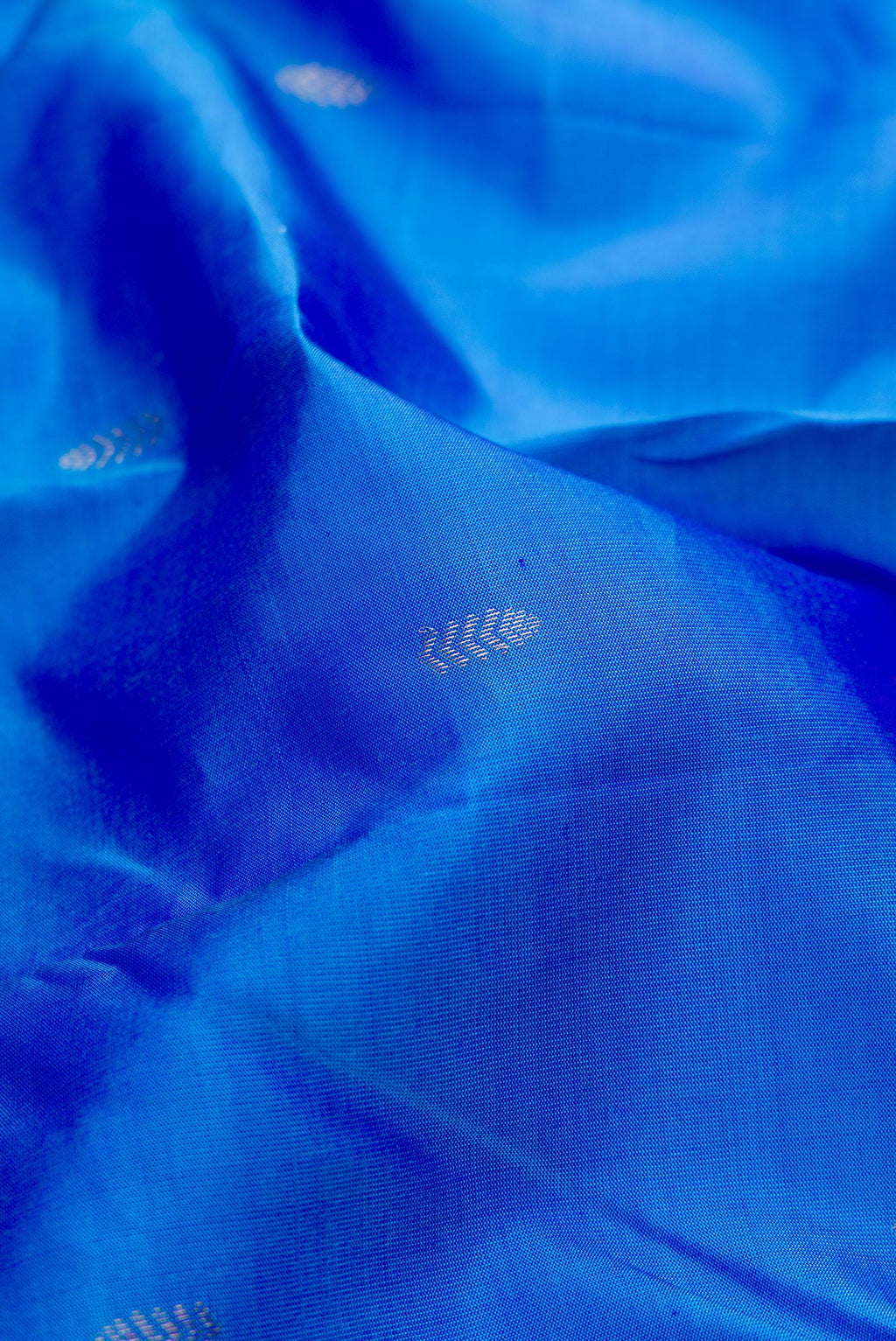 Close up of Blue Kanchipuram Silk Saree with Zari Butta on the body and Without Border.  displaying folds