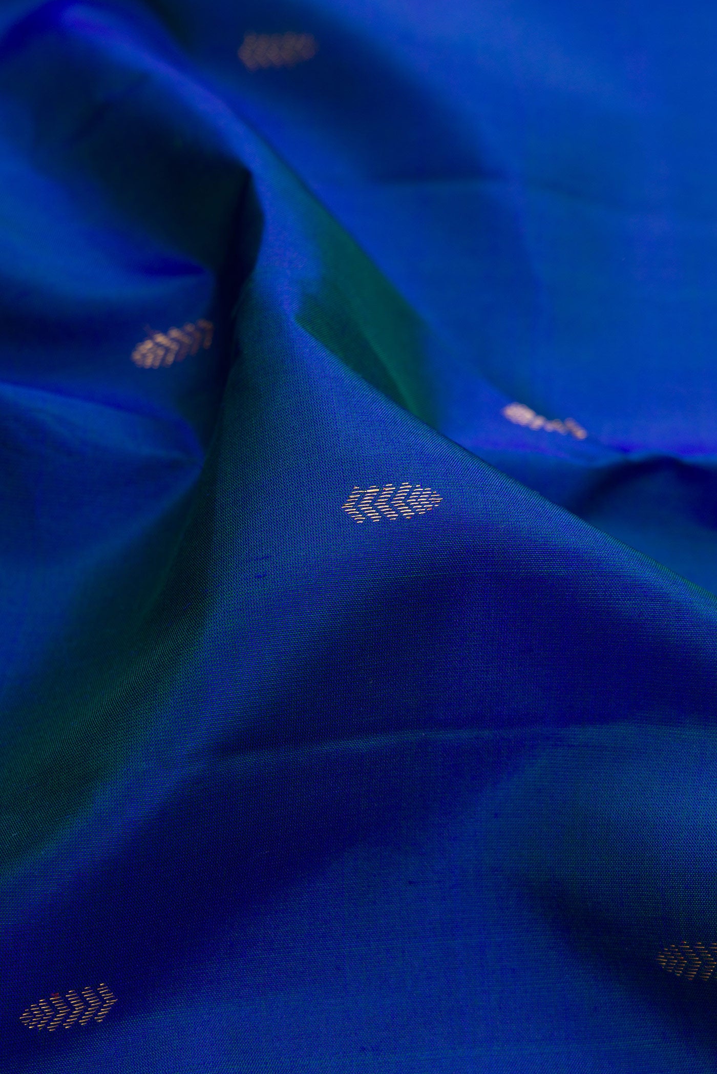 Close up of Peacock Blue Kanchipuram Silk Saree with Zari Butta on the body and Fancy Border.  displaying folds