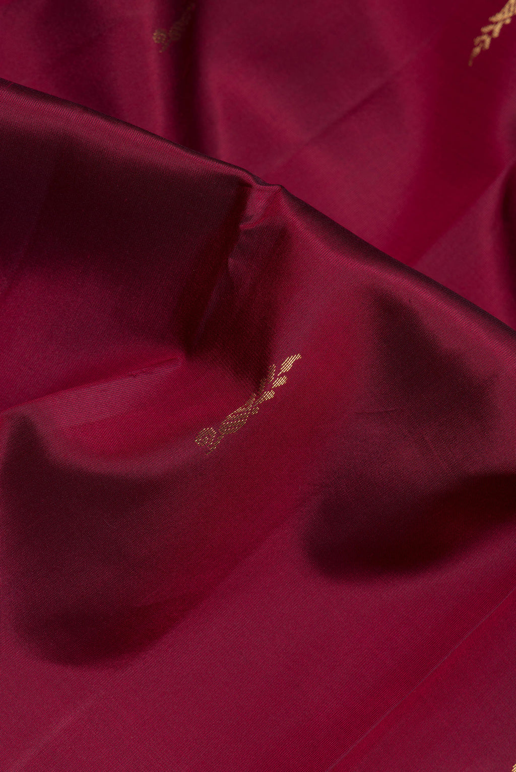Close up of Maroon Dual Tone Blended Kanjivaram Silk Saree with Zari Butta on the body and Zari Border.  displaying folds