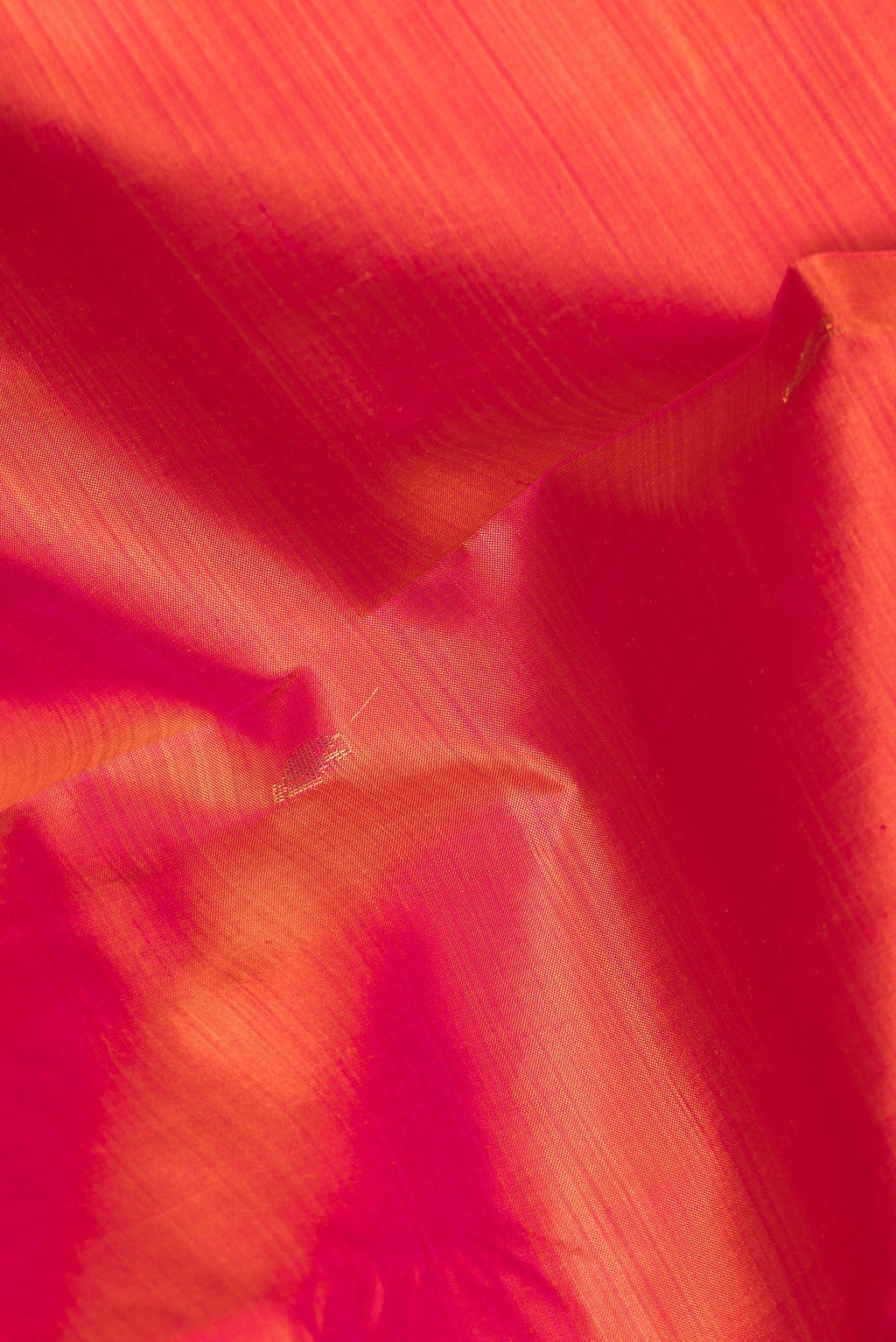 Close up of Pure Silk Brick Orange Kanjivaram Saree with Zari Butta on the body and Zari Border.  displaying folds