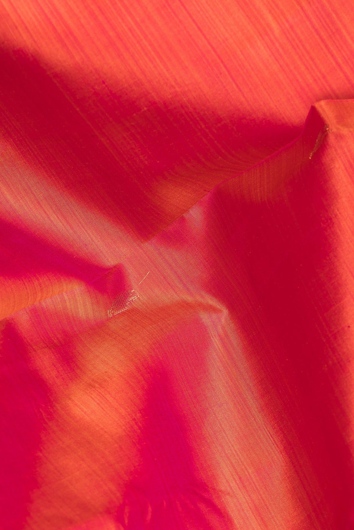 Close up of Pure Silk Brick Orange Kanjivaram Saree with Zari Butta on the body and Zari Border.  displaying folds
