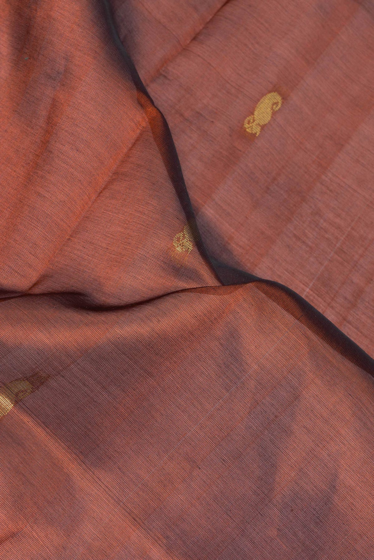 Close up of Brown Silk Cotton Saree with Zari Butta on the body and Zari Border.  displaying folds