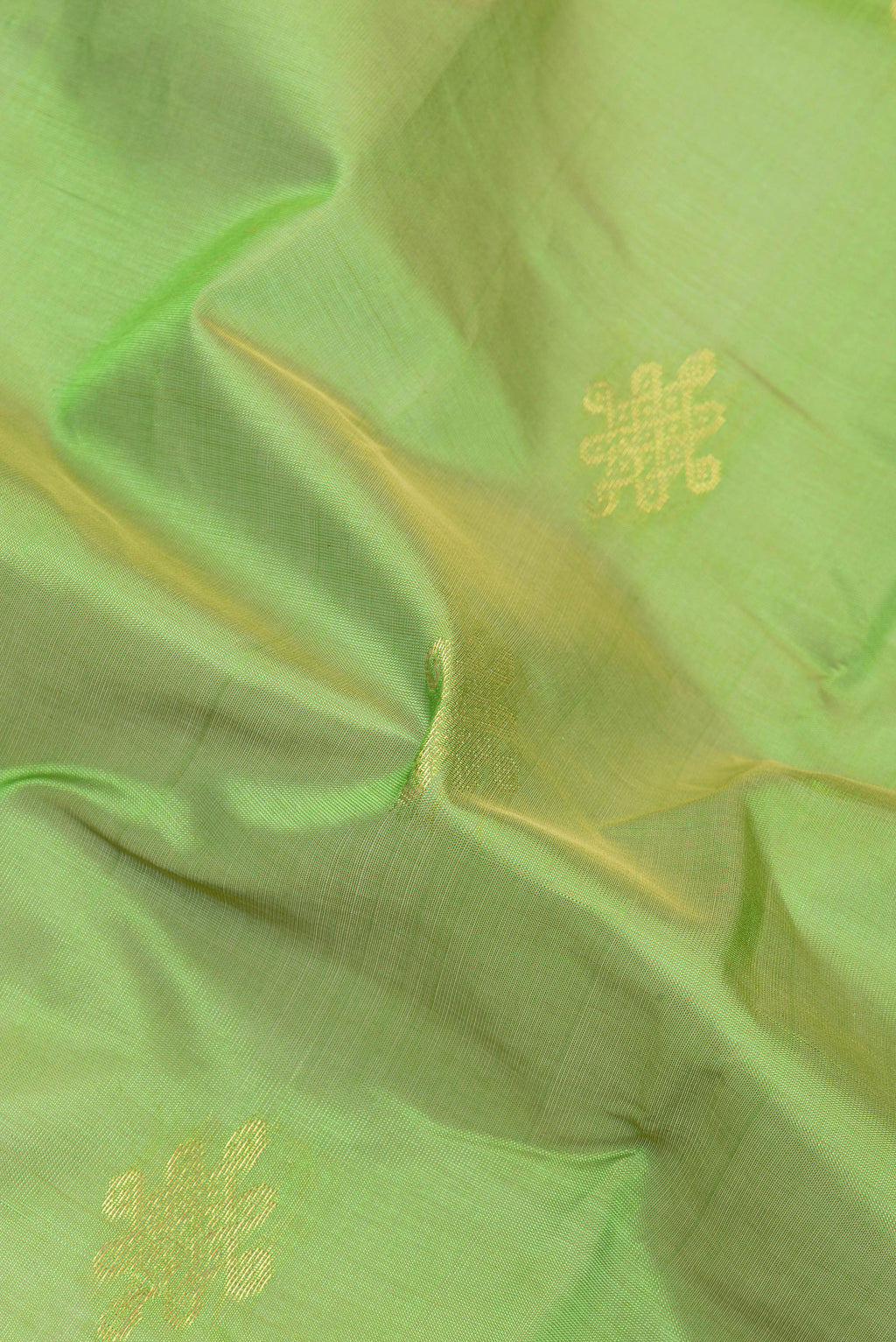 Close up of Light Green Silk Cotton Saree with Zari Butta on the body and Zari Border.  displaying folds
