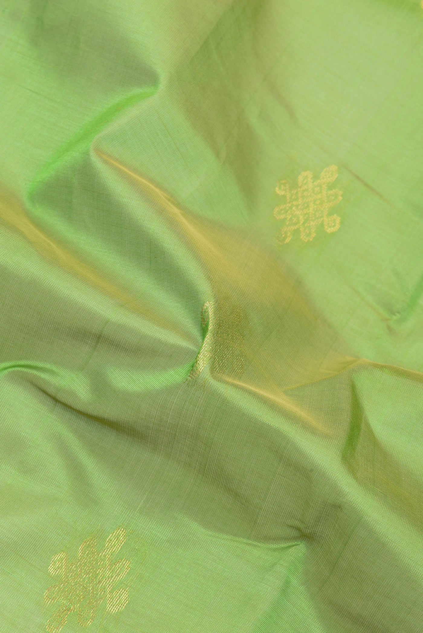 Close up of Light Green Silk Cotton Saree with Zari Butta on the body and Zari Border.  displaying folds