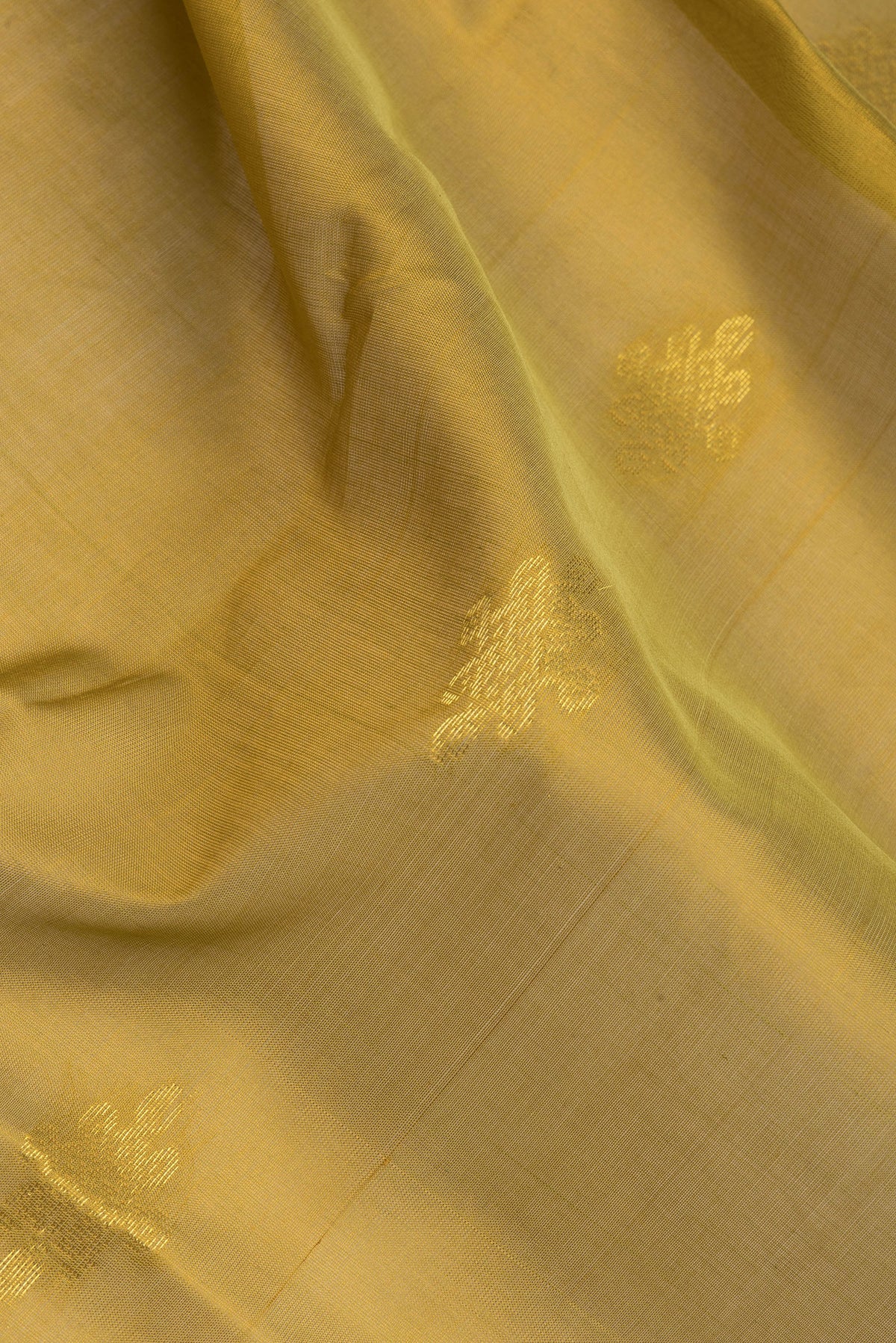 Close up of Mehandi Green Silk Cotton Saree with Zari Butta on the body and Zari Border.  displaying folds