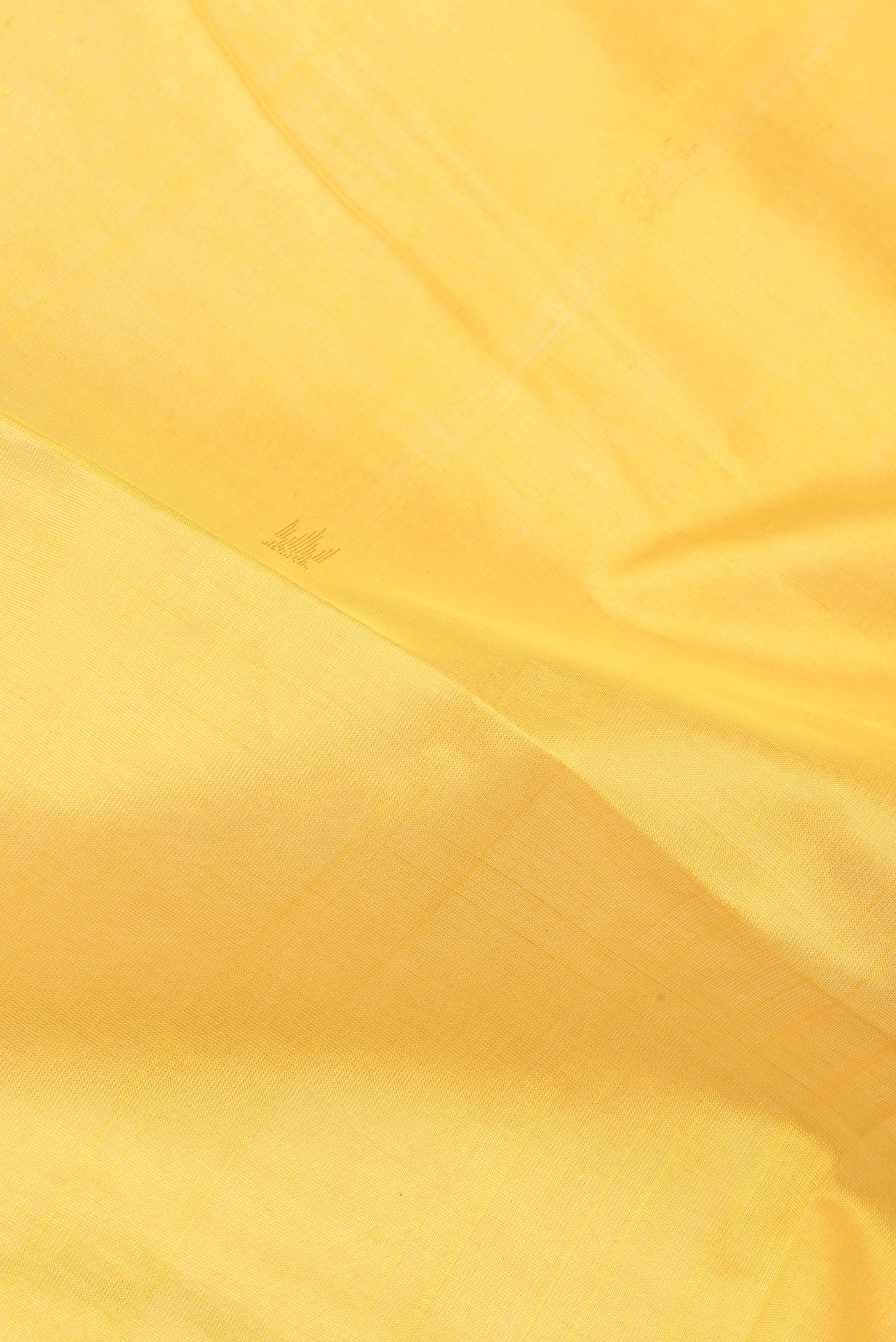Close up of Yellow Silk Cotton Saree with Zari Butta on the body and Zari Border.  displaying folds