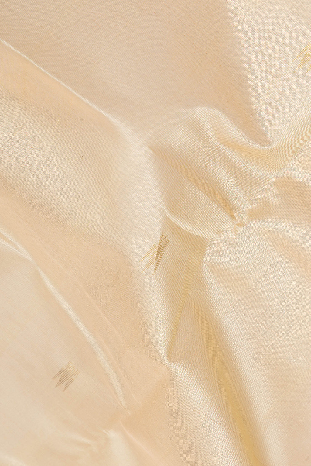 Close up of Beige Silk Cotton Saree with Zari Butta on the body and Zari Border.  displaying folds