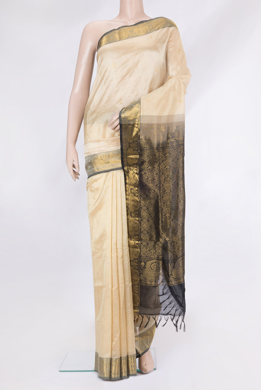 Beige Silk Cotton Saree with Zari Butta on the body and Zari Border.  displayed on a mannequin