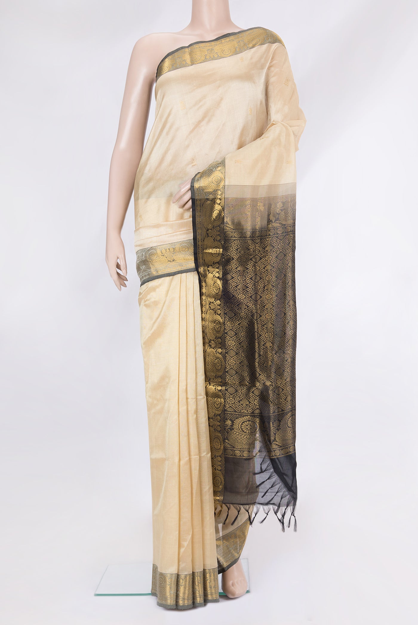 Beige Silk Cotton Saree with Zari Butta on the body and Zari Border.  displayed on a mannequin