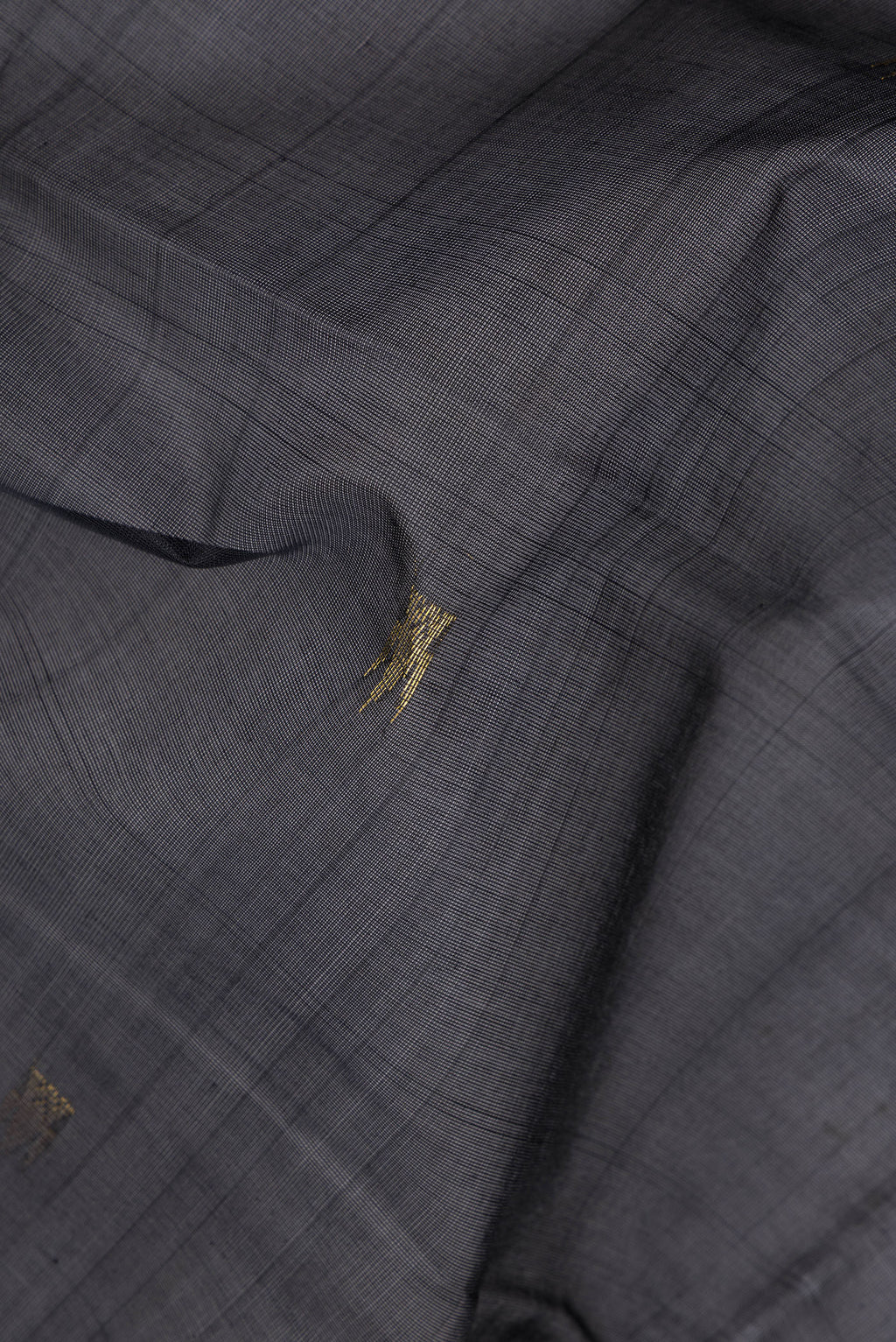 Close up of Black Silk Cotton Saree with Zari Butta on the body and Zari Border.  displaying folds