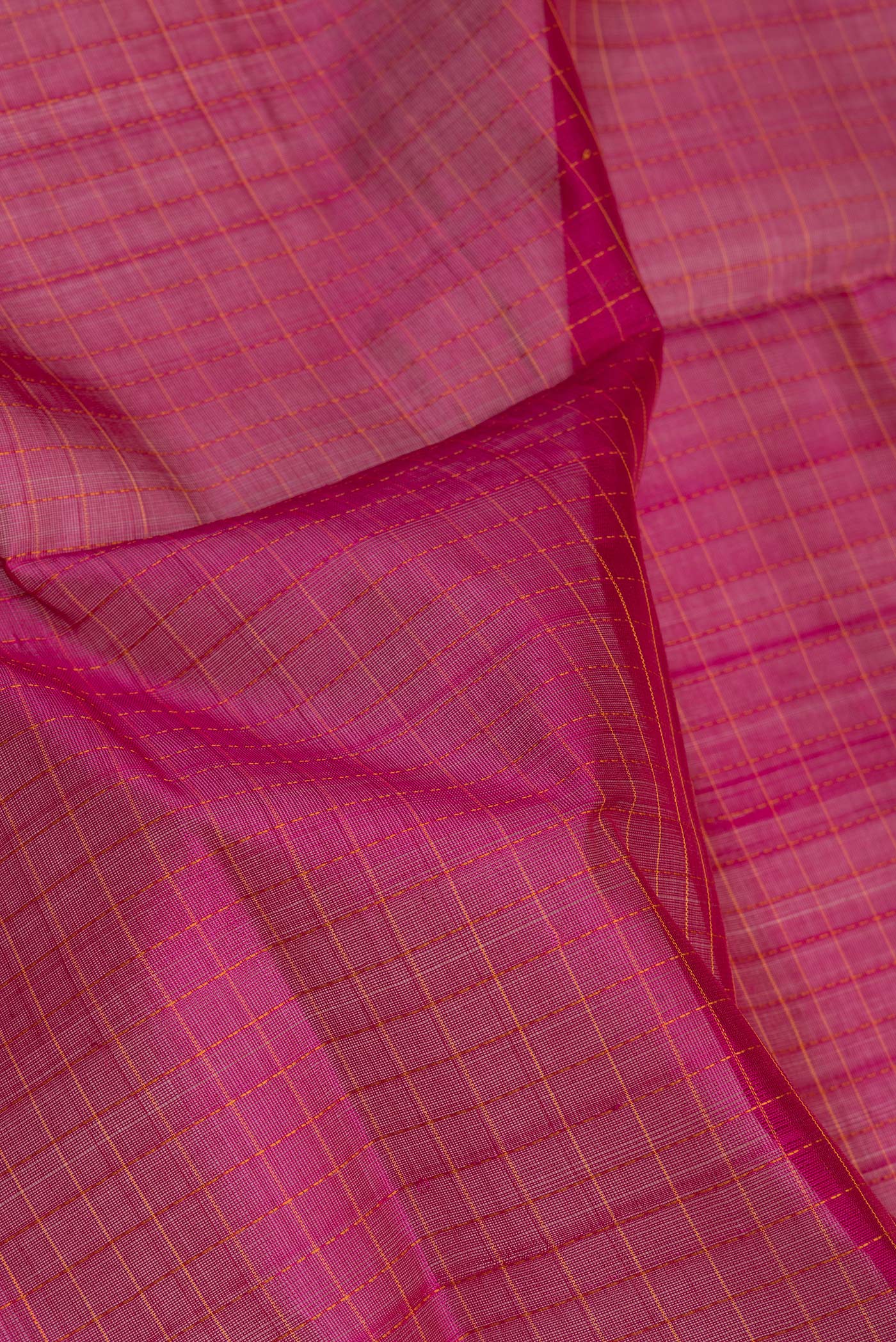 Close up of Magenta Silk Cotton Saree with Checked design on the body and Zari Border.  displaying folds