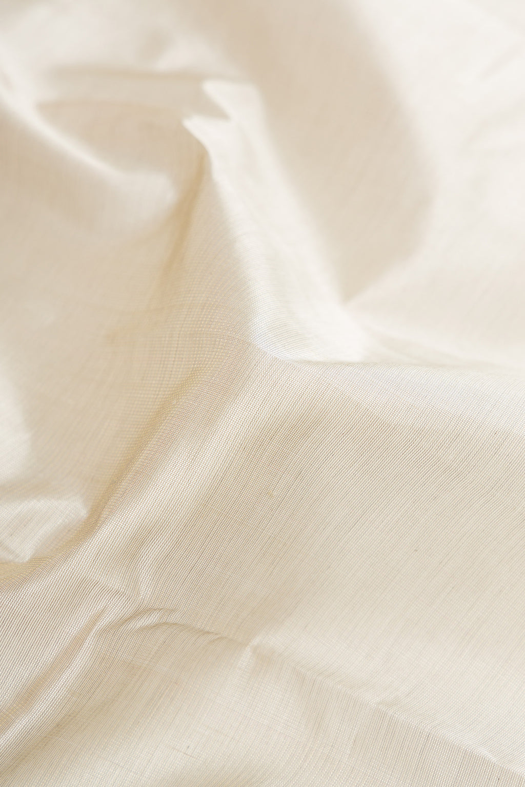 Close up of Grey Silk Cotton Saree with Plain Body and Zari Border.  displaying folds