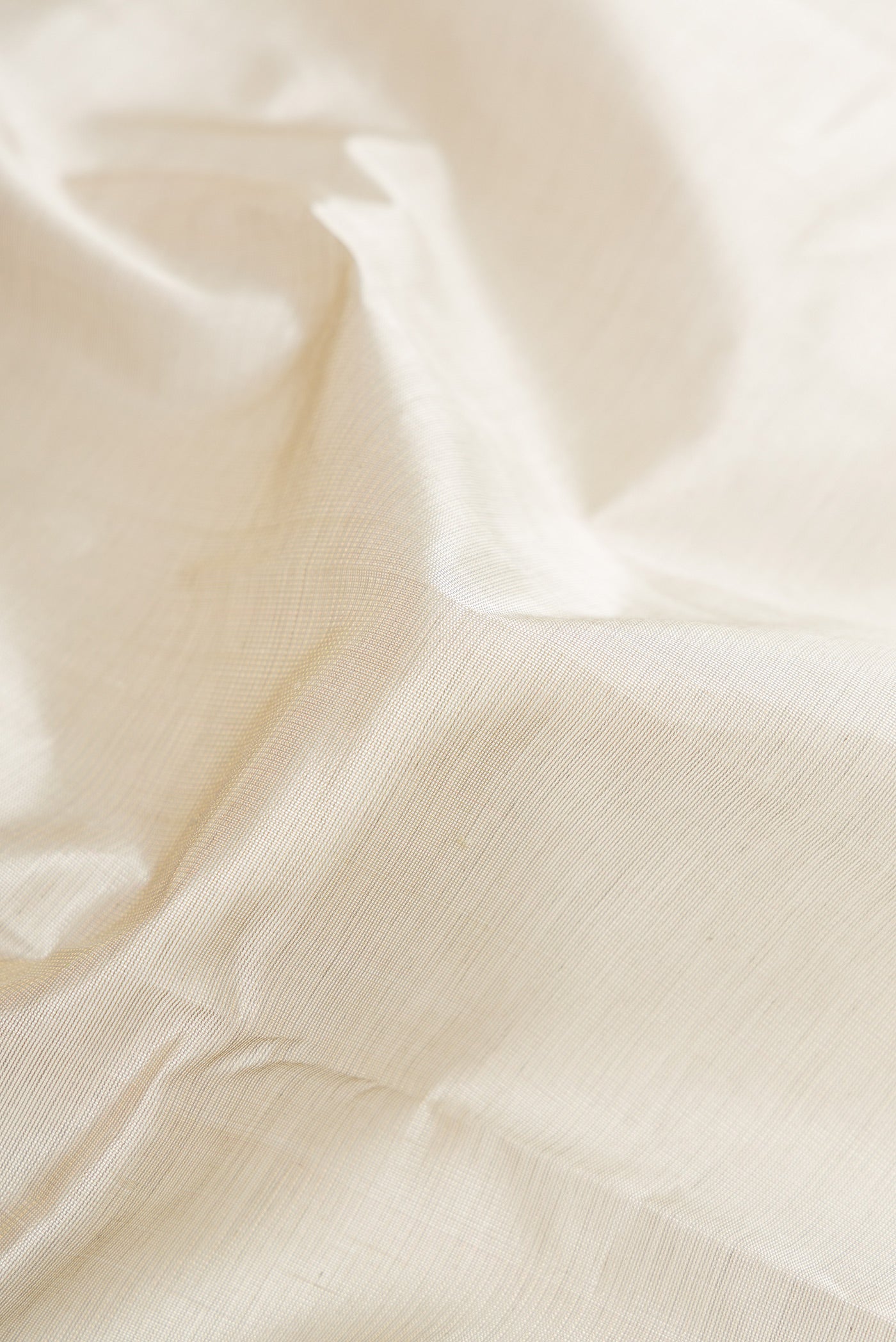 Close up of Grey Silk Cotton Saree with Plain Body and Zari Border.  displaying folds