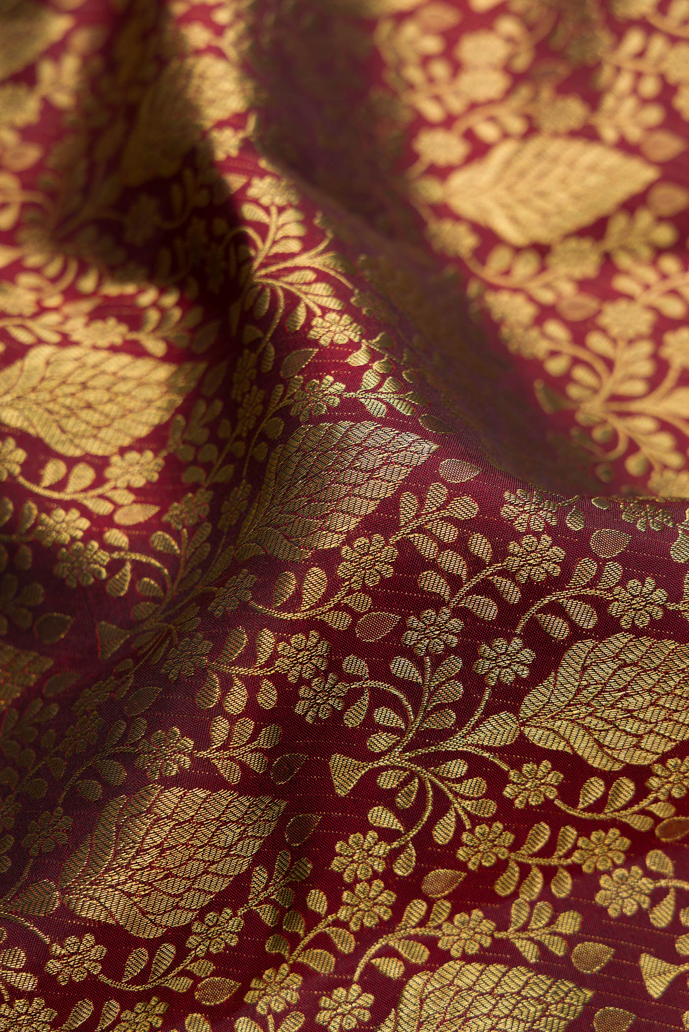 Close up of Maroon Kanchipuram Silk Saree with Zari Brocade on the body and Zari Border.  displaying folds
