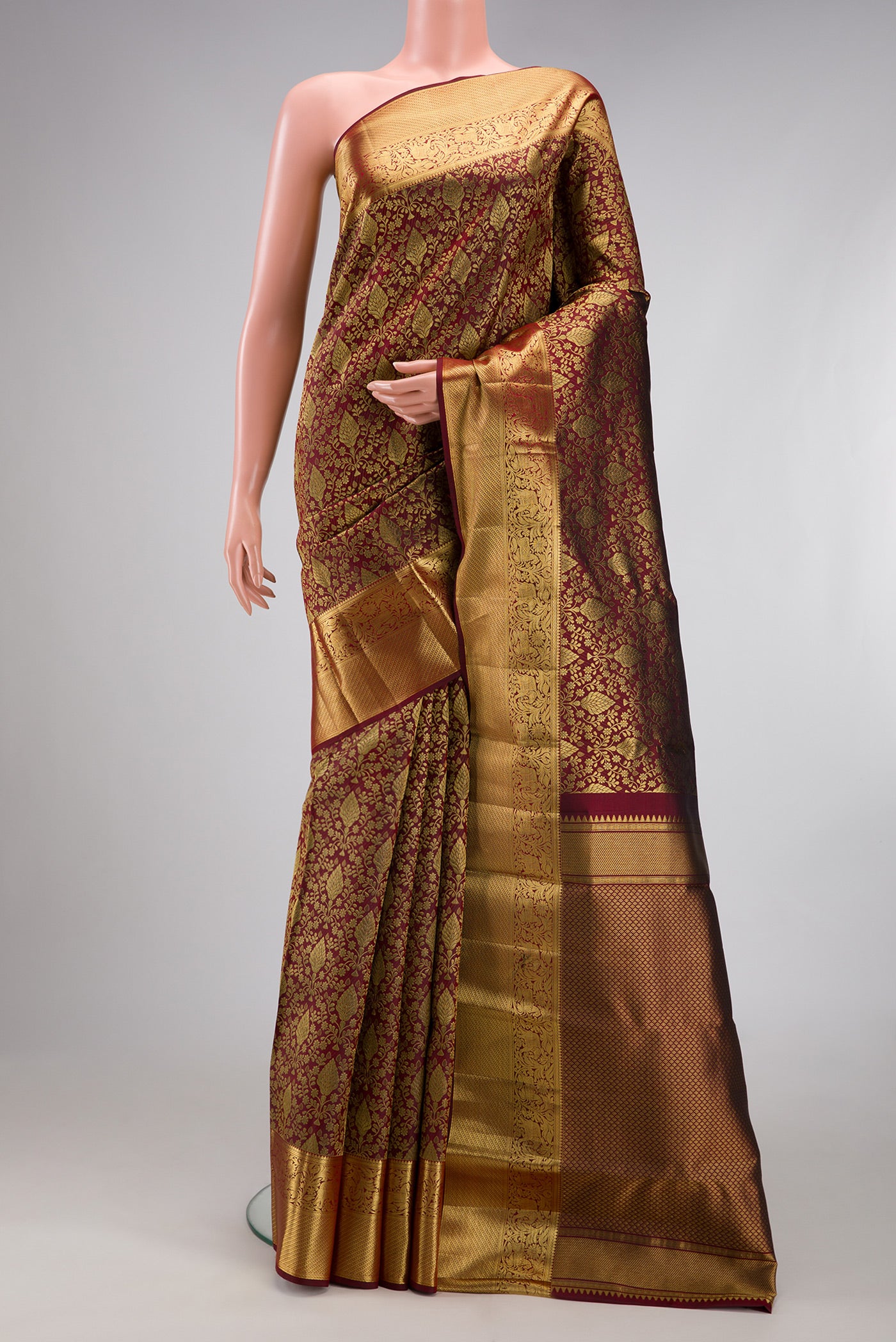 Maroon Kanchipuram Silk Saree with Zari Brocade on the body and Zari Border.  displayed on a mannequin