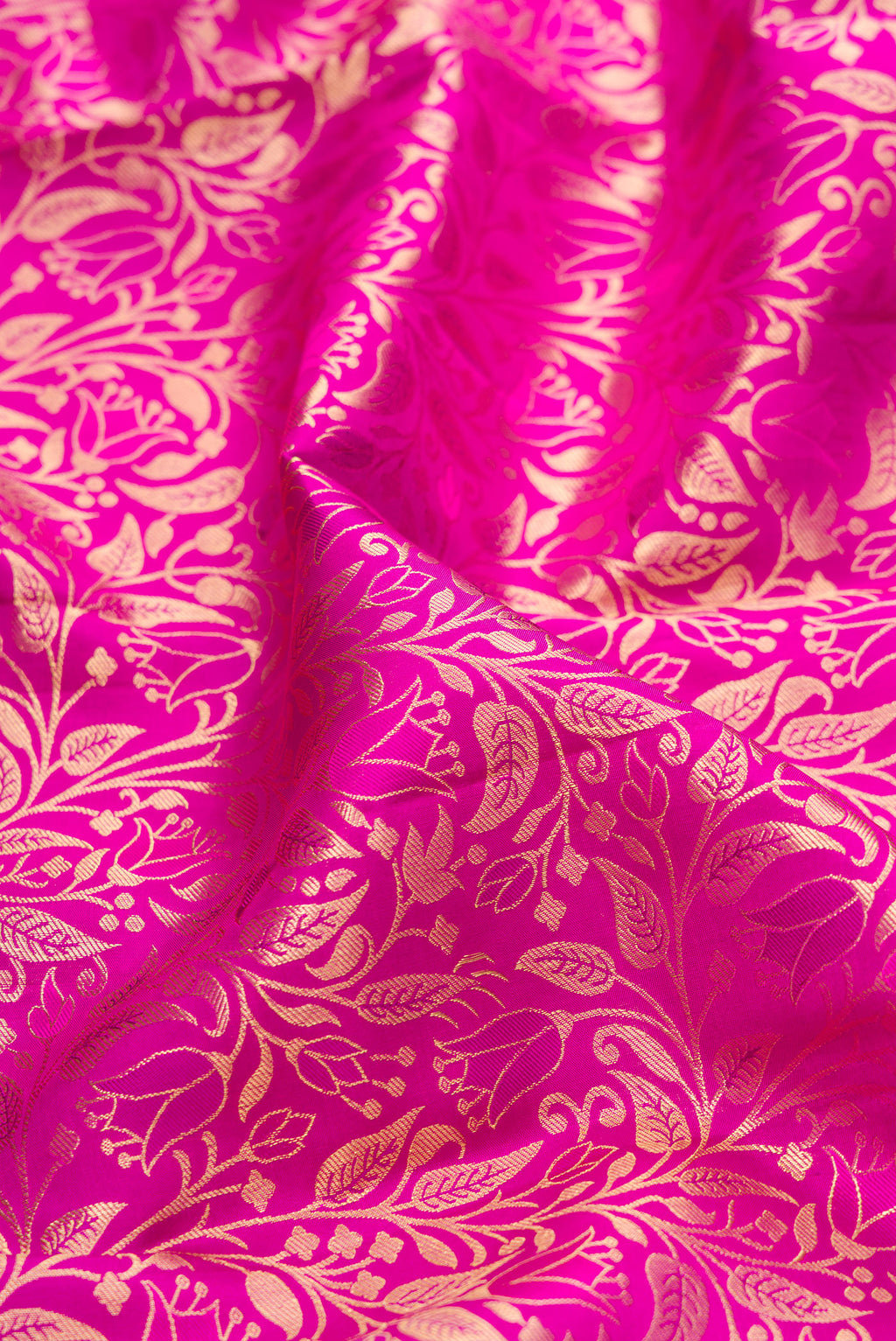 Close up of Magenta Kanchipuram Silk Saree with Zari Brocade on the body and Zari Border.  displaying folds