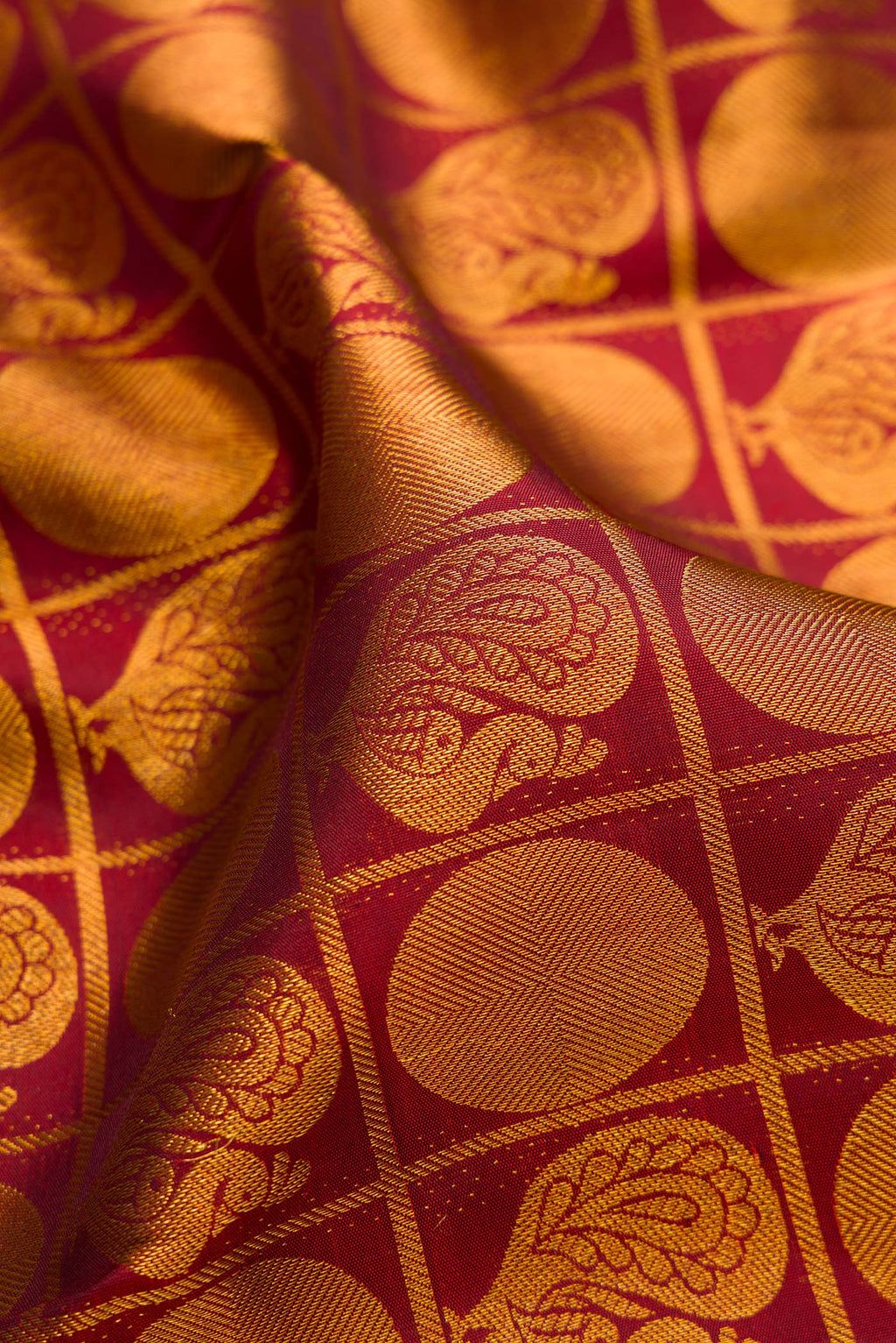 Close up of Maroon Kanchipuram Silk Saree with Zari Brocade on the body and Zari Border.  displaying folds
