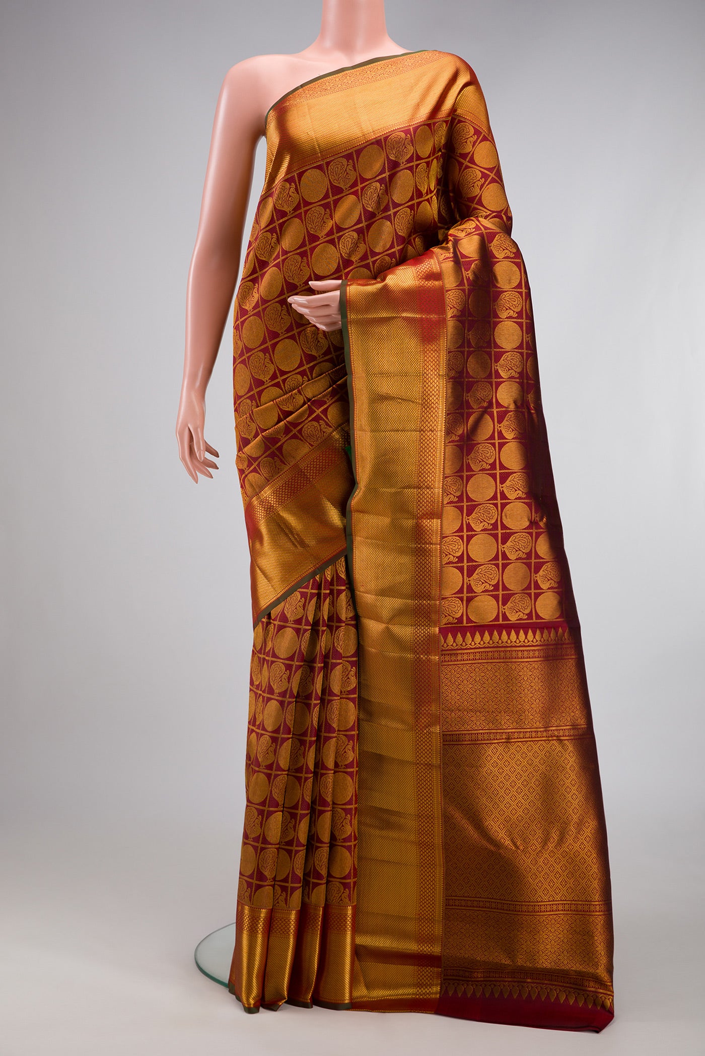 Maroon Kanchipuram Silk Saree with Zari Brocade on the body and Zari Border.  displayed on a mannequin