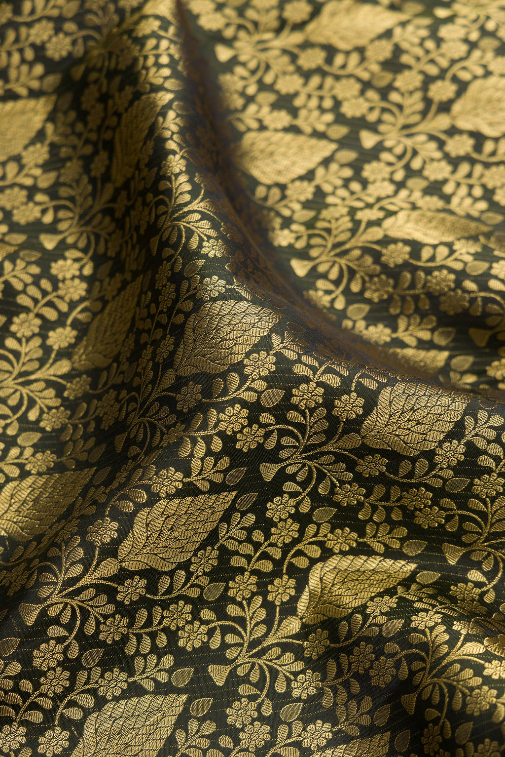 Close up of Bottle Green Kanchipuram Silk Saree with Zari Brocade on the body and Zari Border.  displaying folds