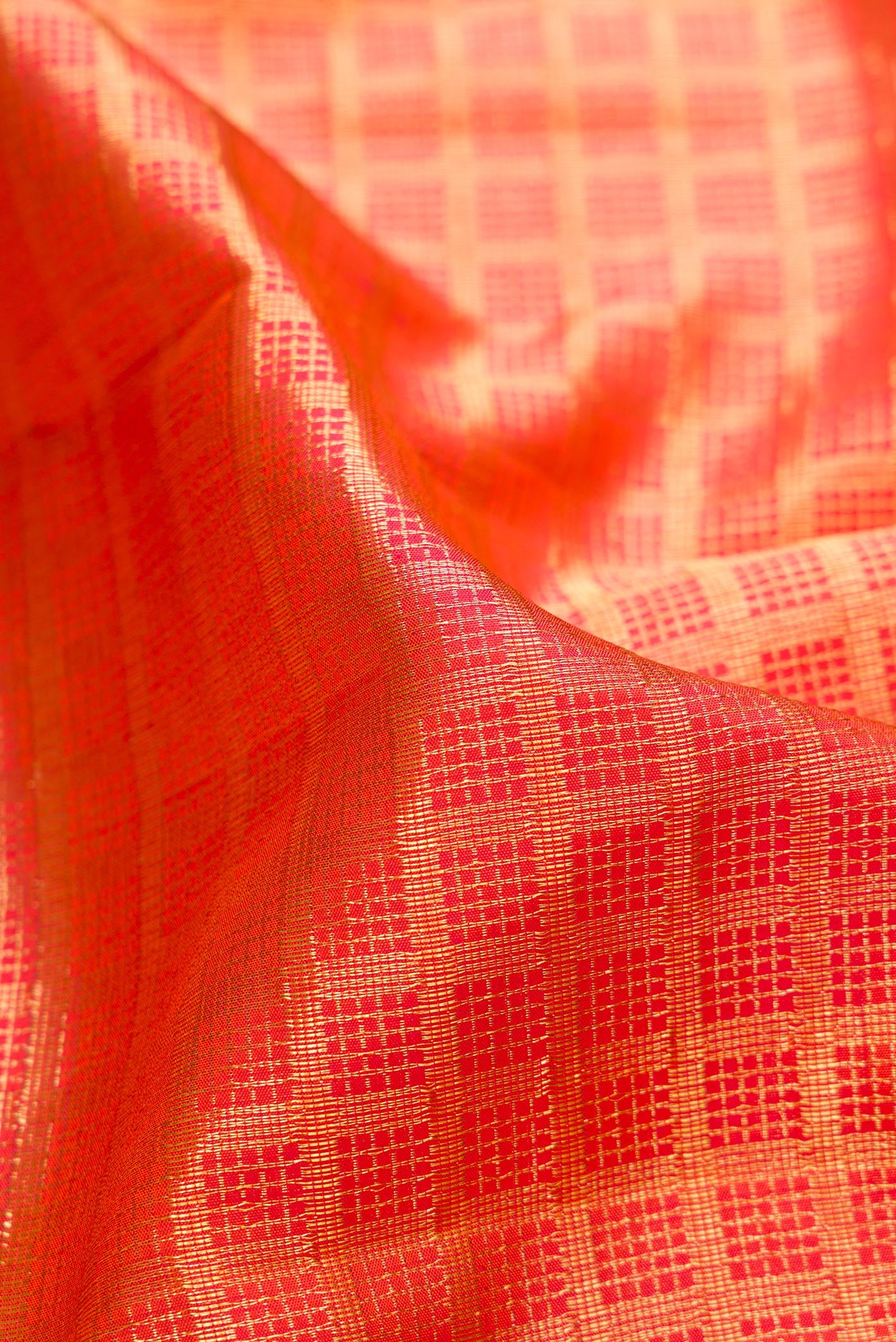 Close up of Orange Kanchipuram Silk Saree with Zari Brocade on the body and Zari Border.  displaying folds