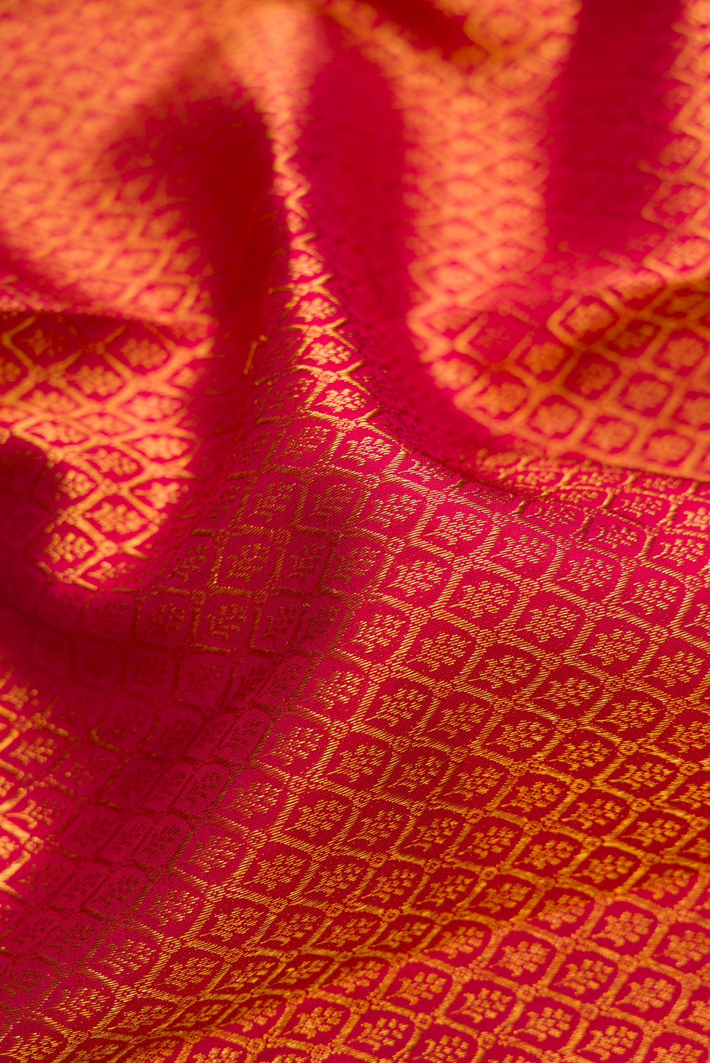 Close up of Maroon Kanchipuram Silk Saree with Zari Brocade on the body and Zari Border.  displaying folds