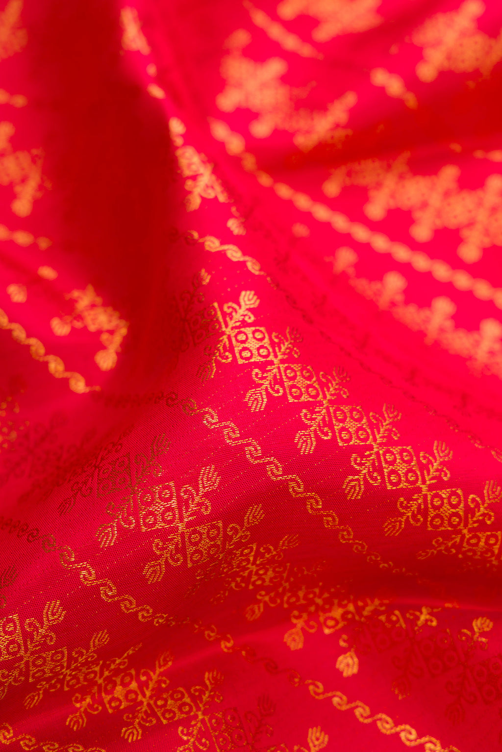 Close up of Red Kanchipuram Silk Saree with Zari Brocade on the body and Zari Border.  displaying folds